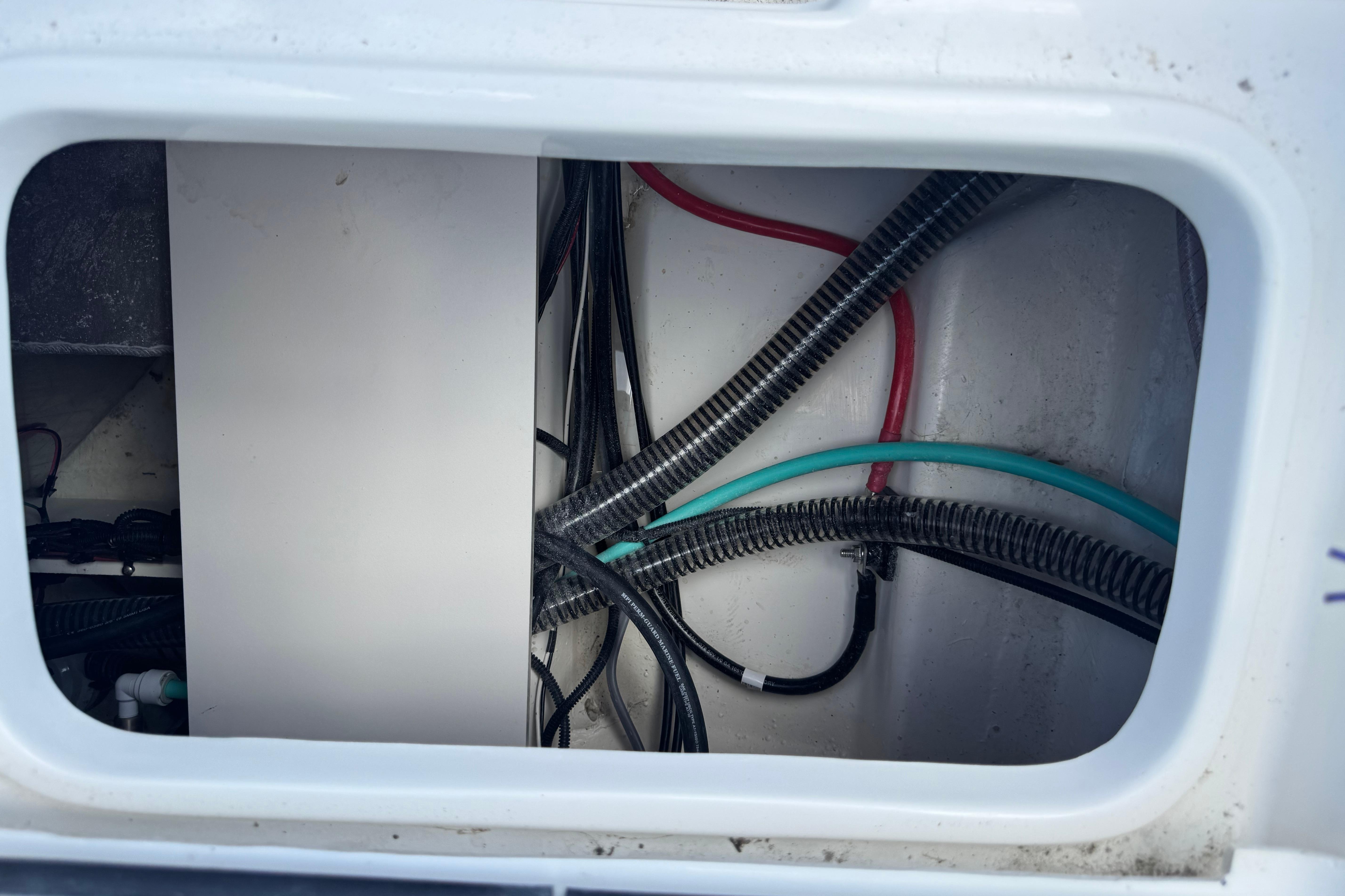 Interior wiring of a 2026 Mako 214 Center Console boat, showcasing cables and conduits.