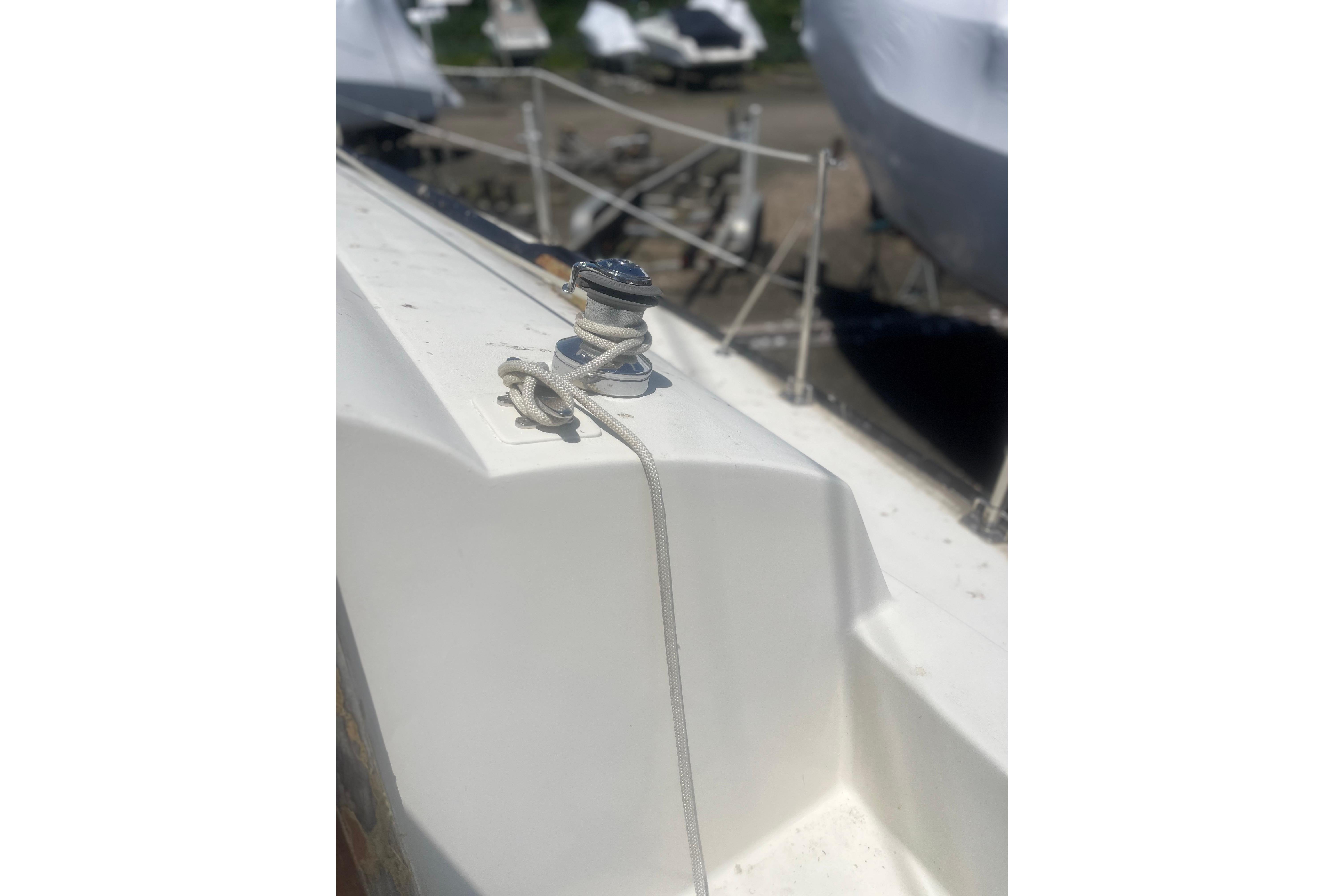 1972 C&C 30 sailboat deck with winch and rope, docked in marina.