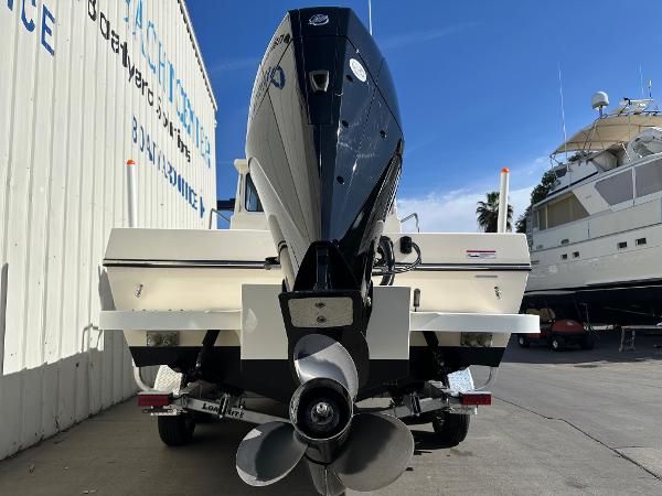 2023 Defiance Admiral 220 EX boat with powerful outboard motor, docked at a marina.