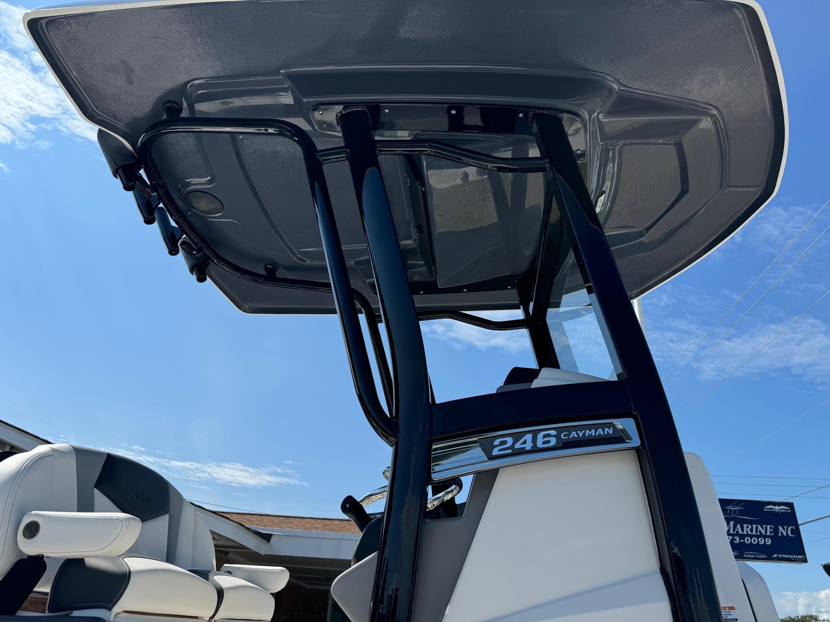 2025 Robalo R246 CAYMAN boat with T-top and seating, under clear blue sky.