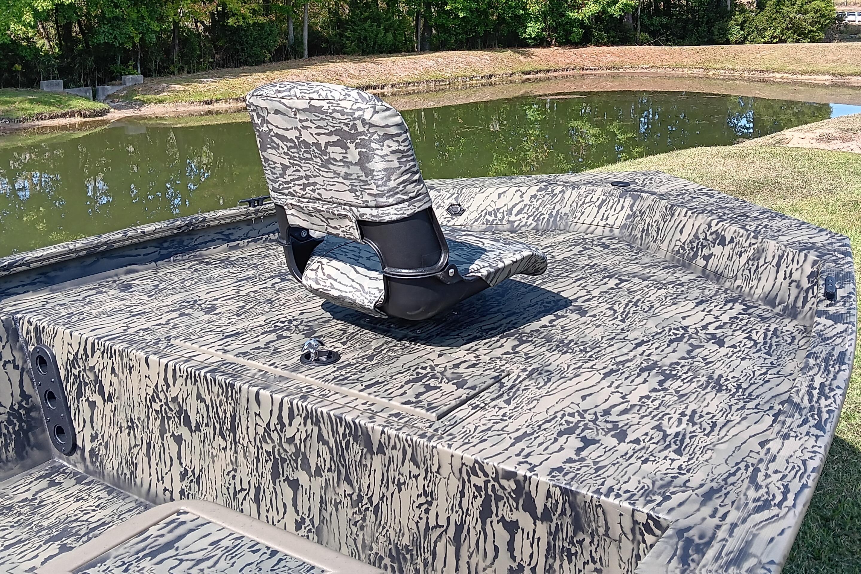 2026 Tracker Grizzly 1754 SC boat with camouflage design by a pond.