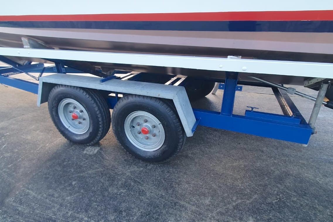 Trailer for 1989 Fairey Spearfish MKIII boat with dual wheels on concrete surface.