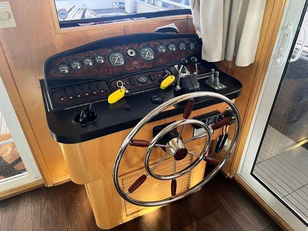 Helm of 2005 Sumerset 90x18 houseboat with steering wheel and control panel.
