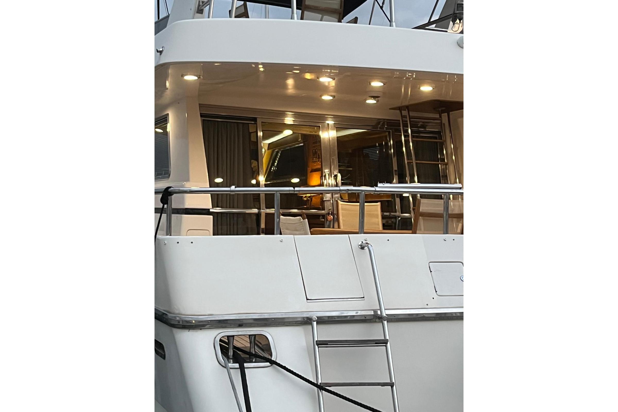 1993 Canados 58 yacht exterior with illuminated interior and ladder.