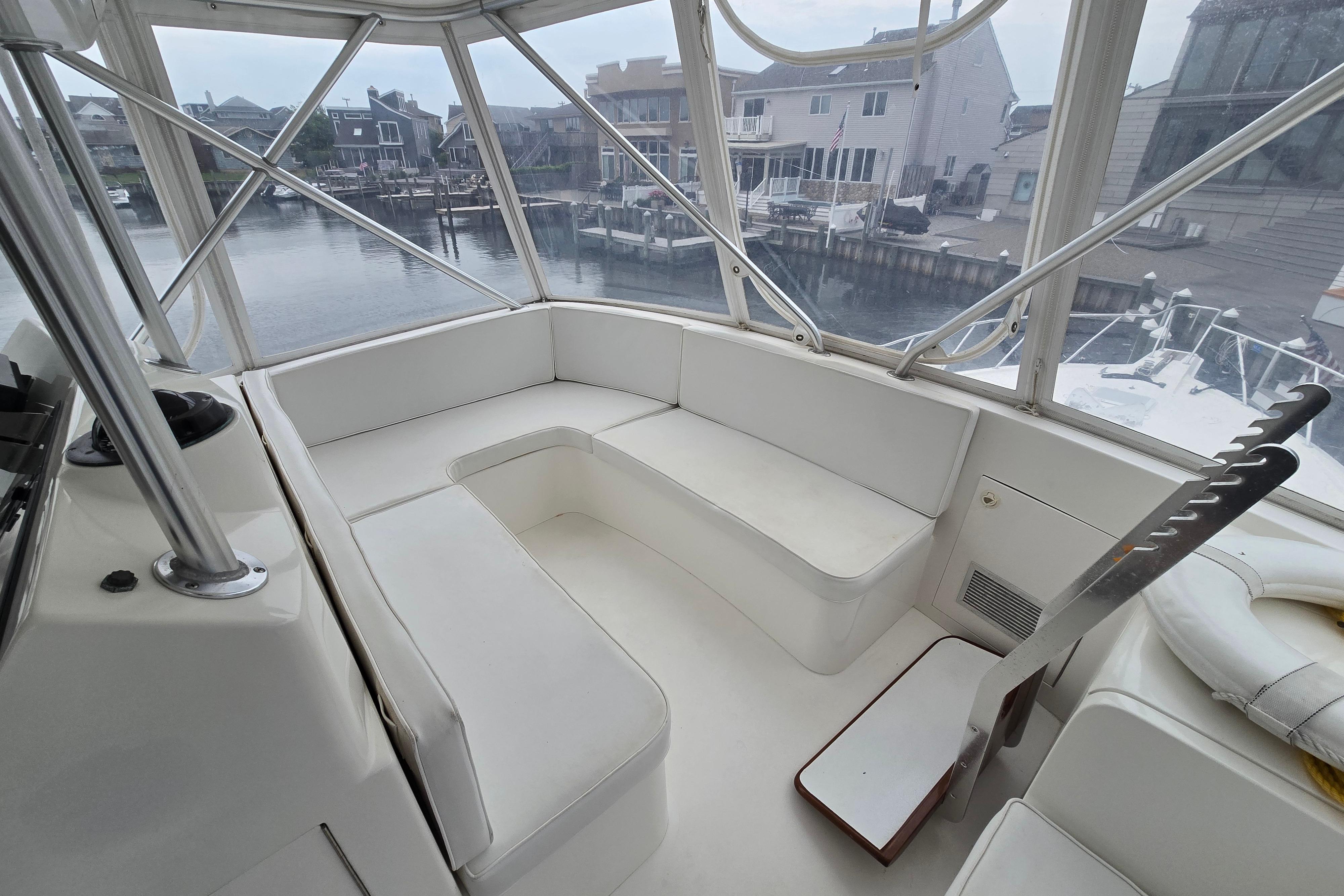 Interior of a 2001 Cavileer 53 Convertible yacht with white seating and waterfront view.