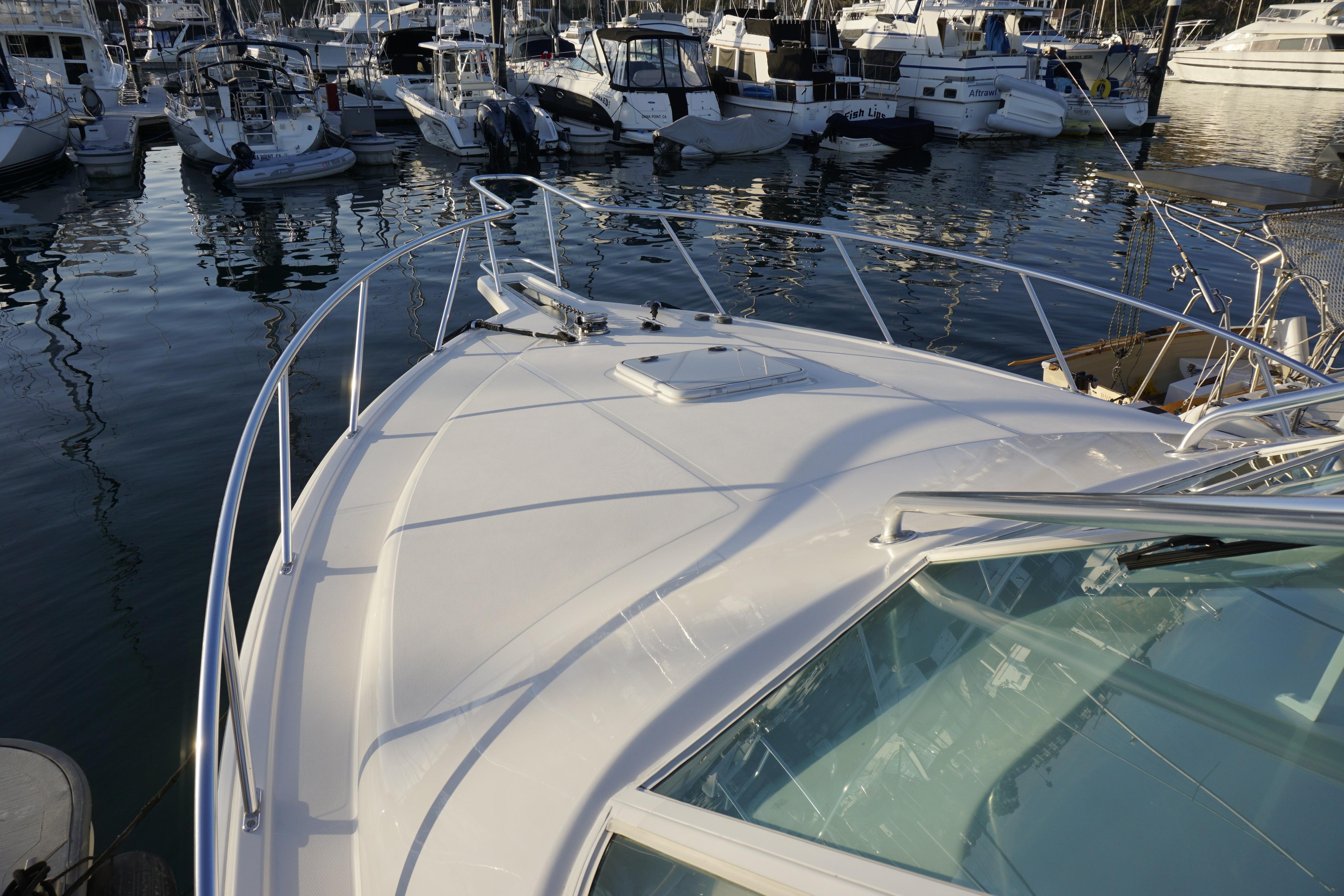2005 Cabo 35 Express yacht docked in a marina, surrounded by other boats.