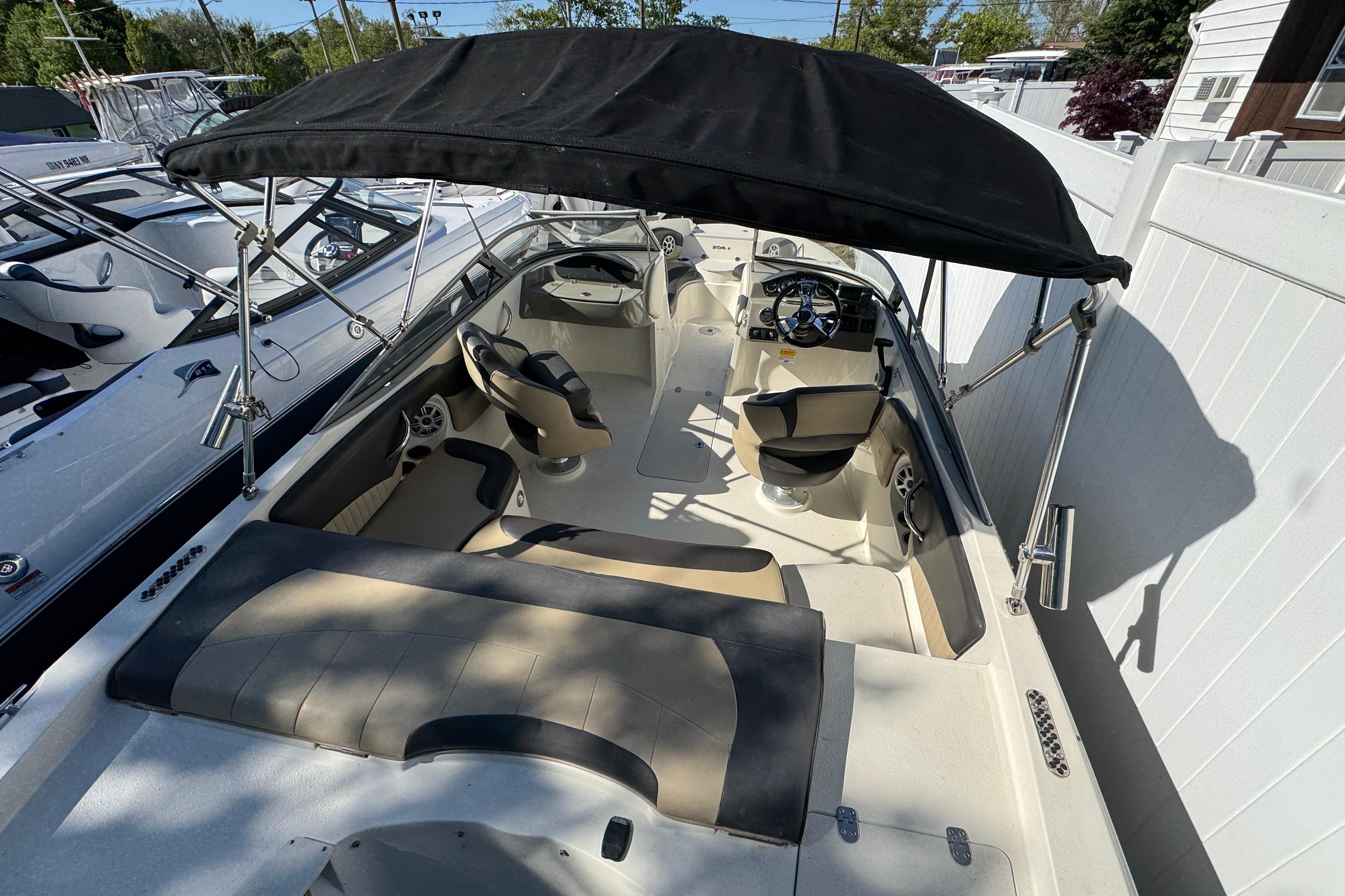 2018 Stingray 204 LR boat interior with seating, steering wheel, and canopy.