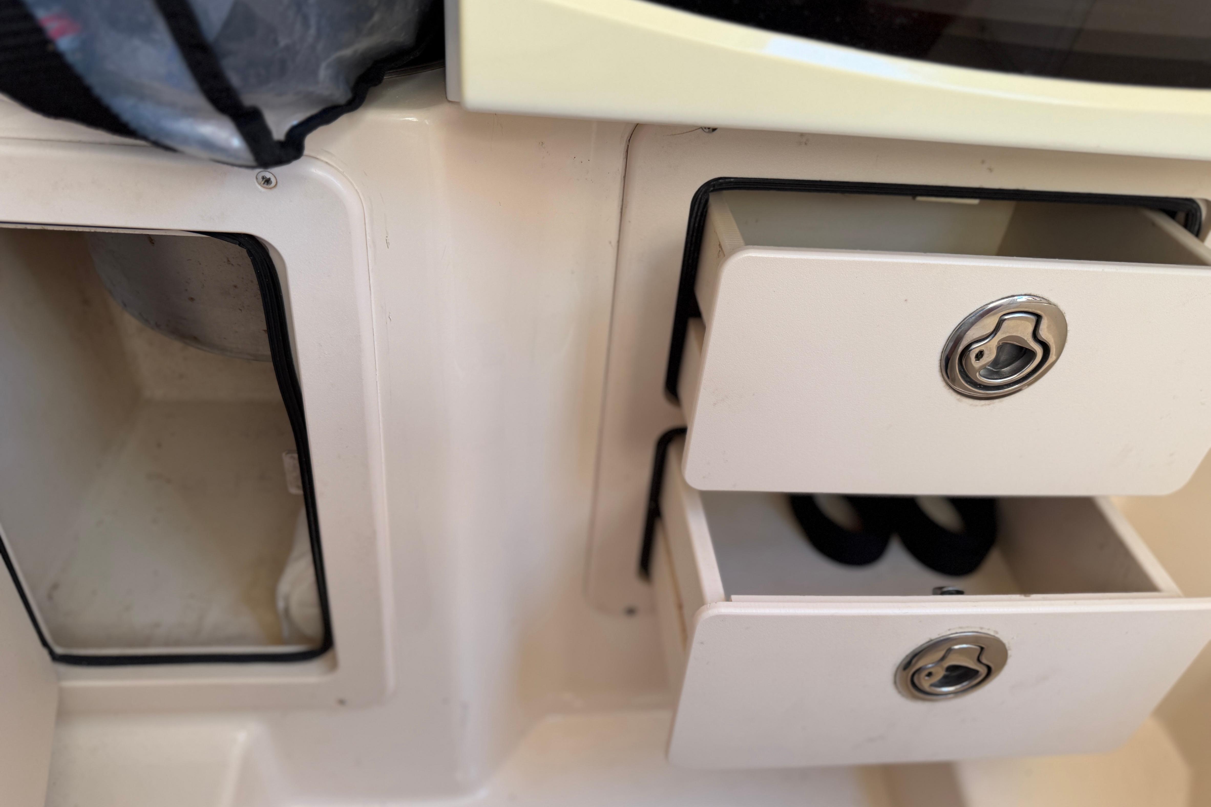 2004 Grady White 273 boat interior with open storage compartments and drawers.