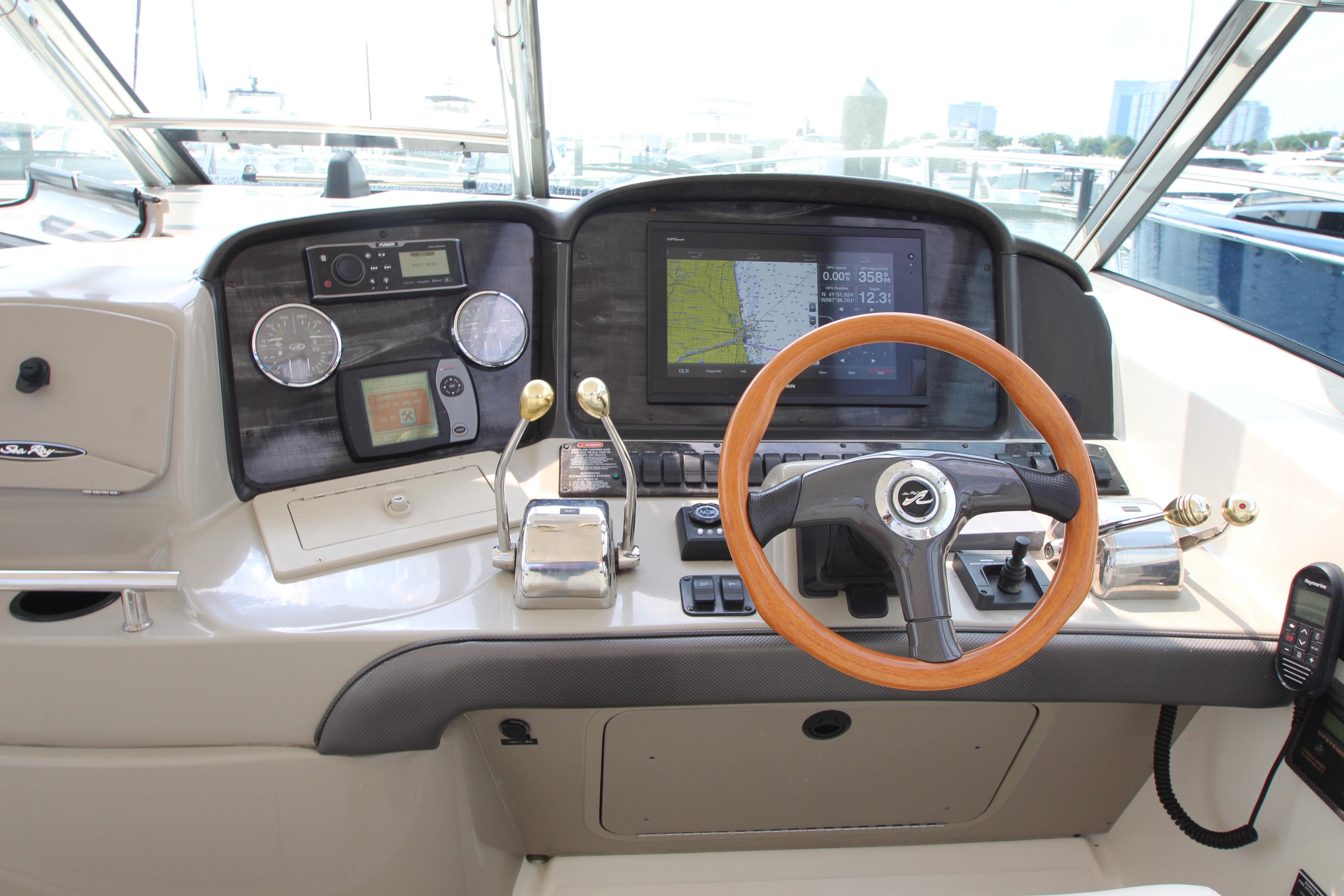 Helm of 2004 Sea Ray 40 Sundancer with navigation equipment and wooden steering wheel.