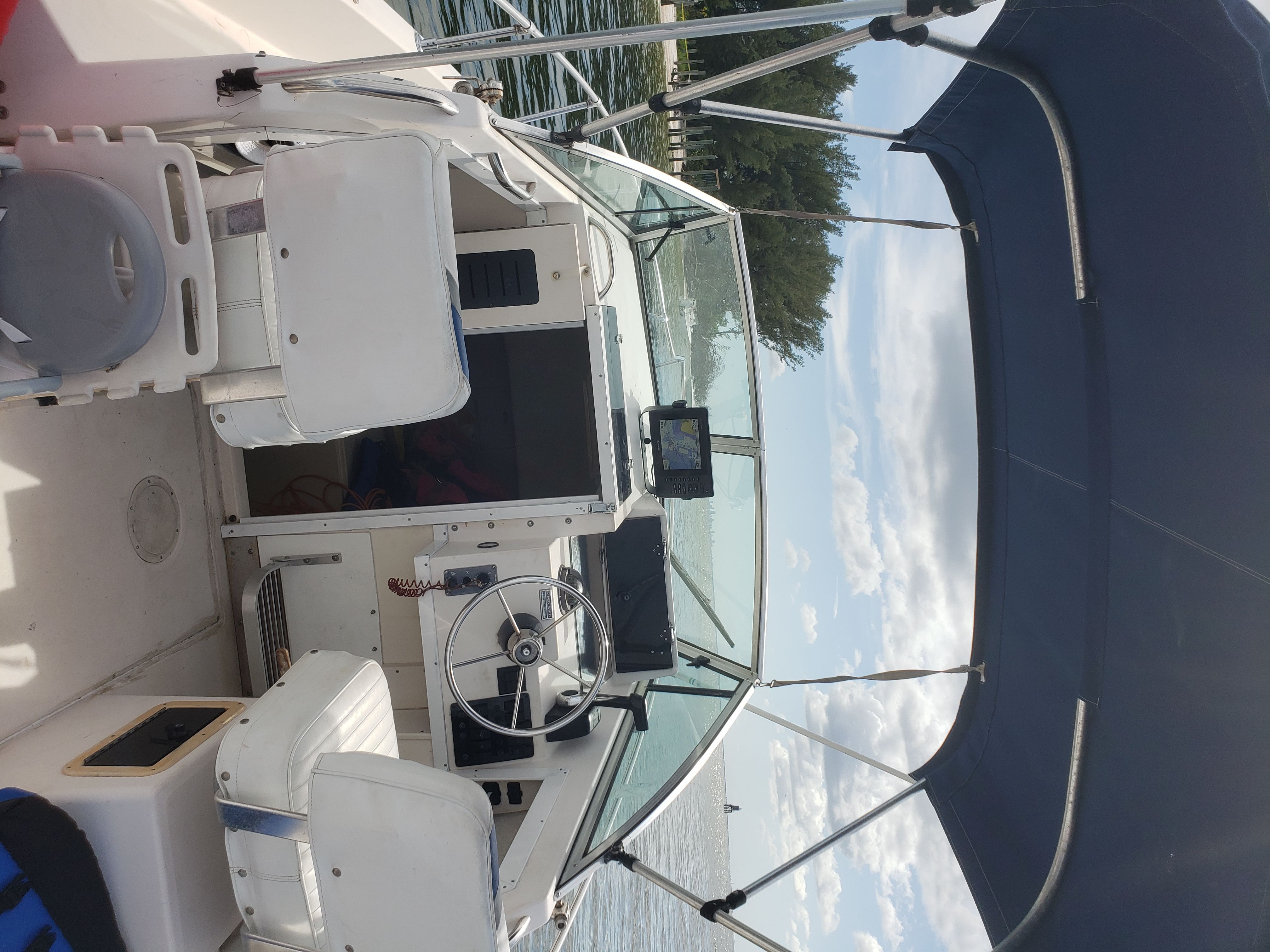 The image shows the cockpit of a 1995 Grady-White Explorer 24 with a blue canopy.
