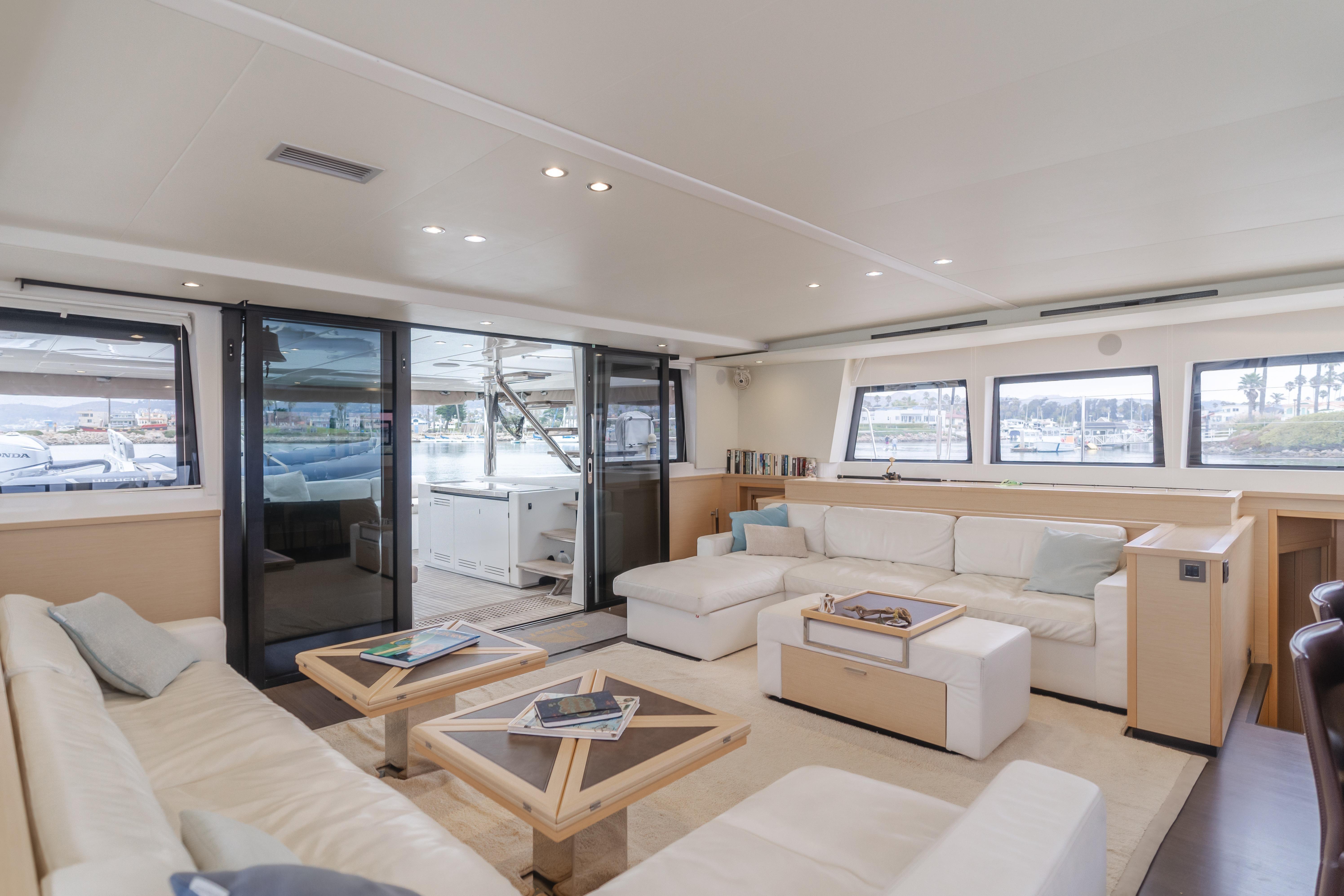 Luxurious interior of 2019 Lagoon 620 yacht with modern furnishings and panoramic windows.