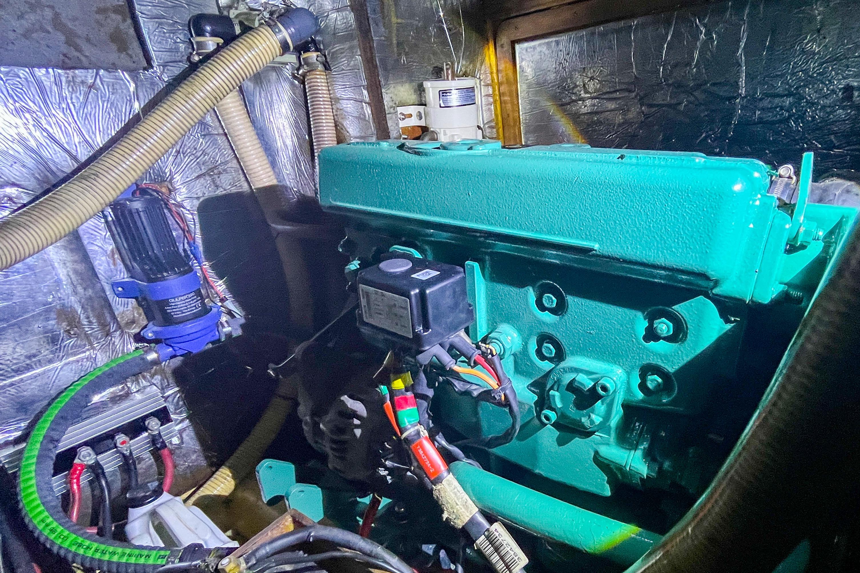 Engine room of a 1991 Oyster LW48 yacht, featuring a green engine and various components.