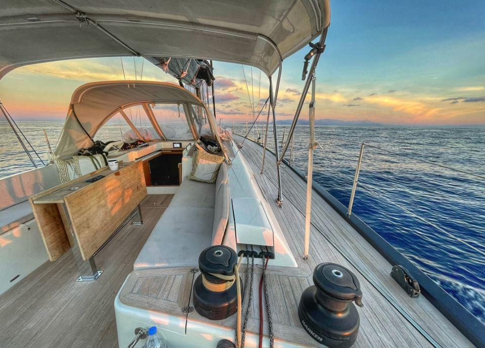 Luxurious 2019 Solaris 50 yacht sailing at sunset on calm ocean waters.