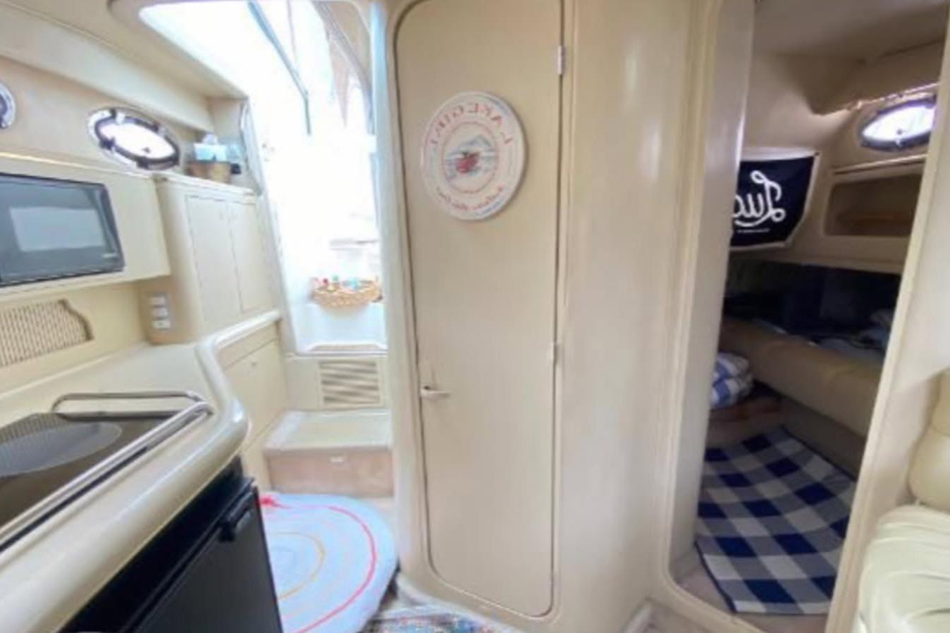 1998 Sea Ray 310 Sundancer interior with kitchenette and cozy cabin area.