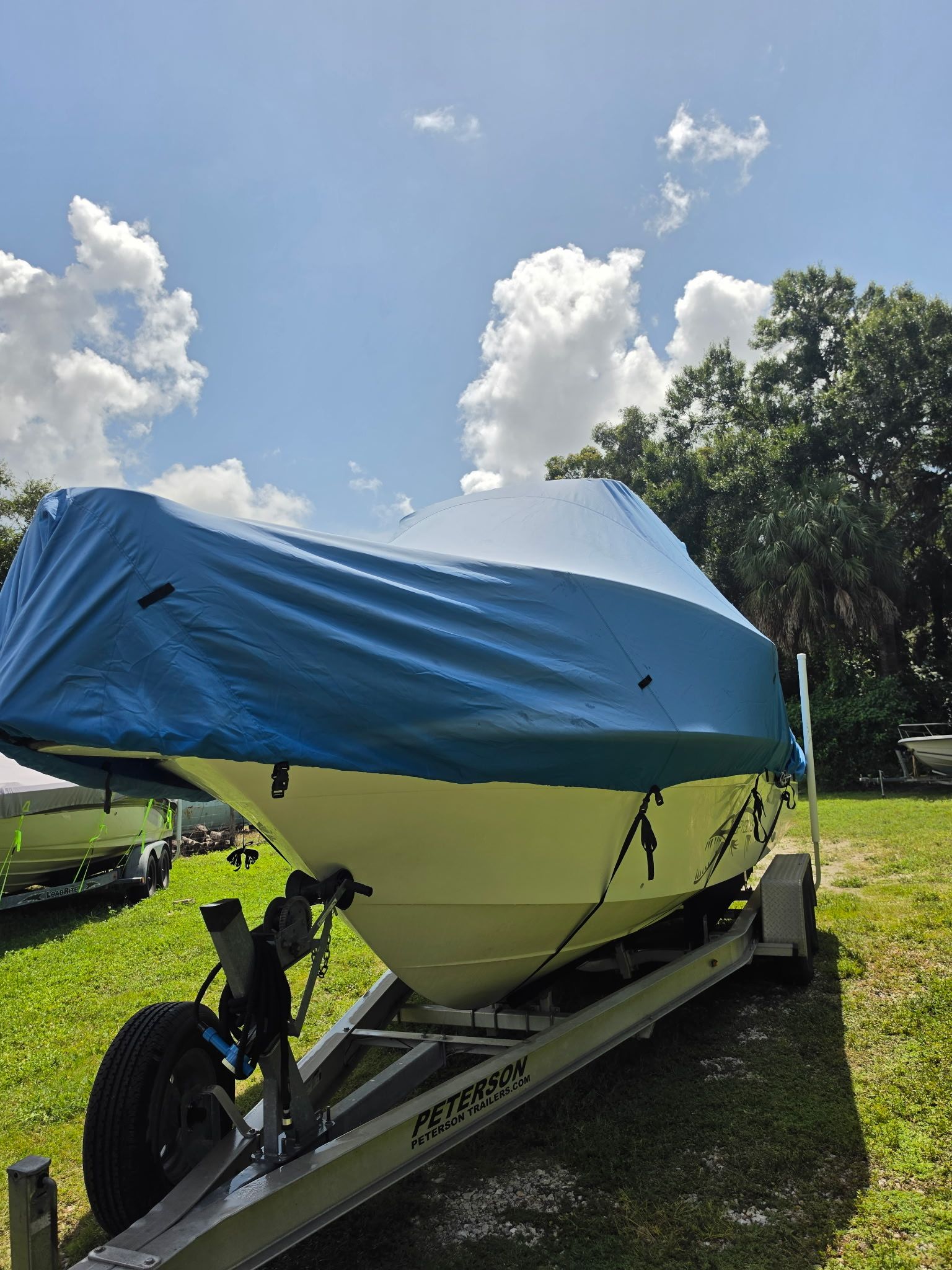 A 2004 Hydra-Sports Lightning 230 CC boat on a trailer, covered with a blue tarp.