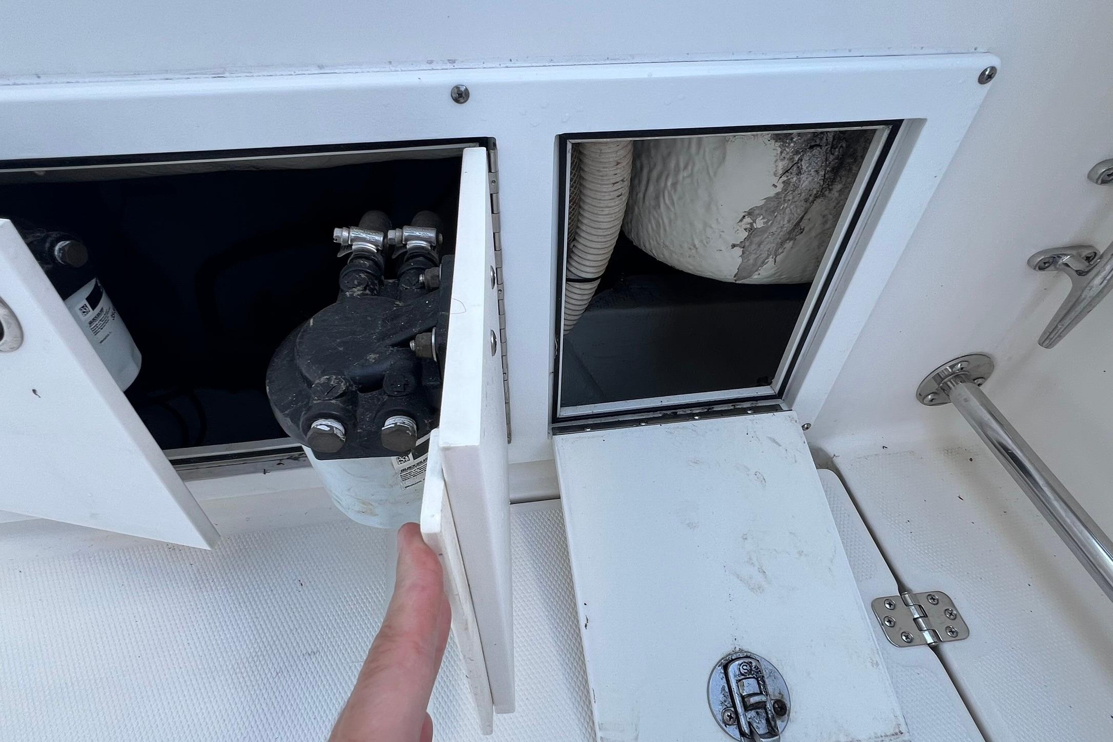 Access panel on a 2006 Edgewater 245CC boat, revealing internal components.
