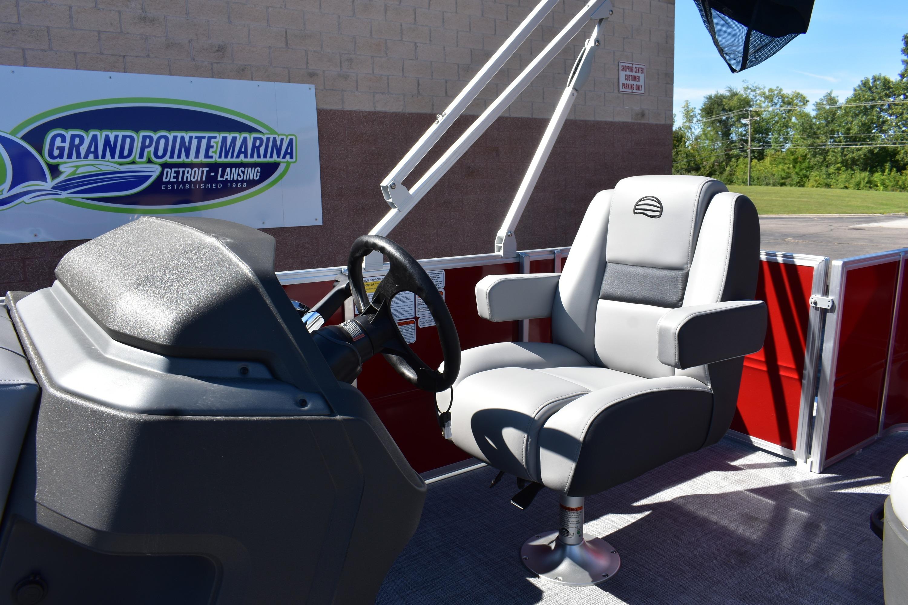 2026 Sun Tracker Party Barge 18 DLX interior with steering wheel and captain's chair.