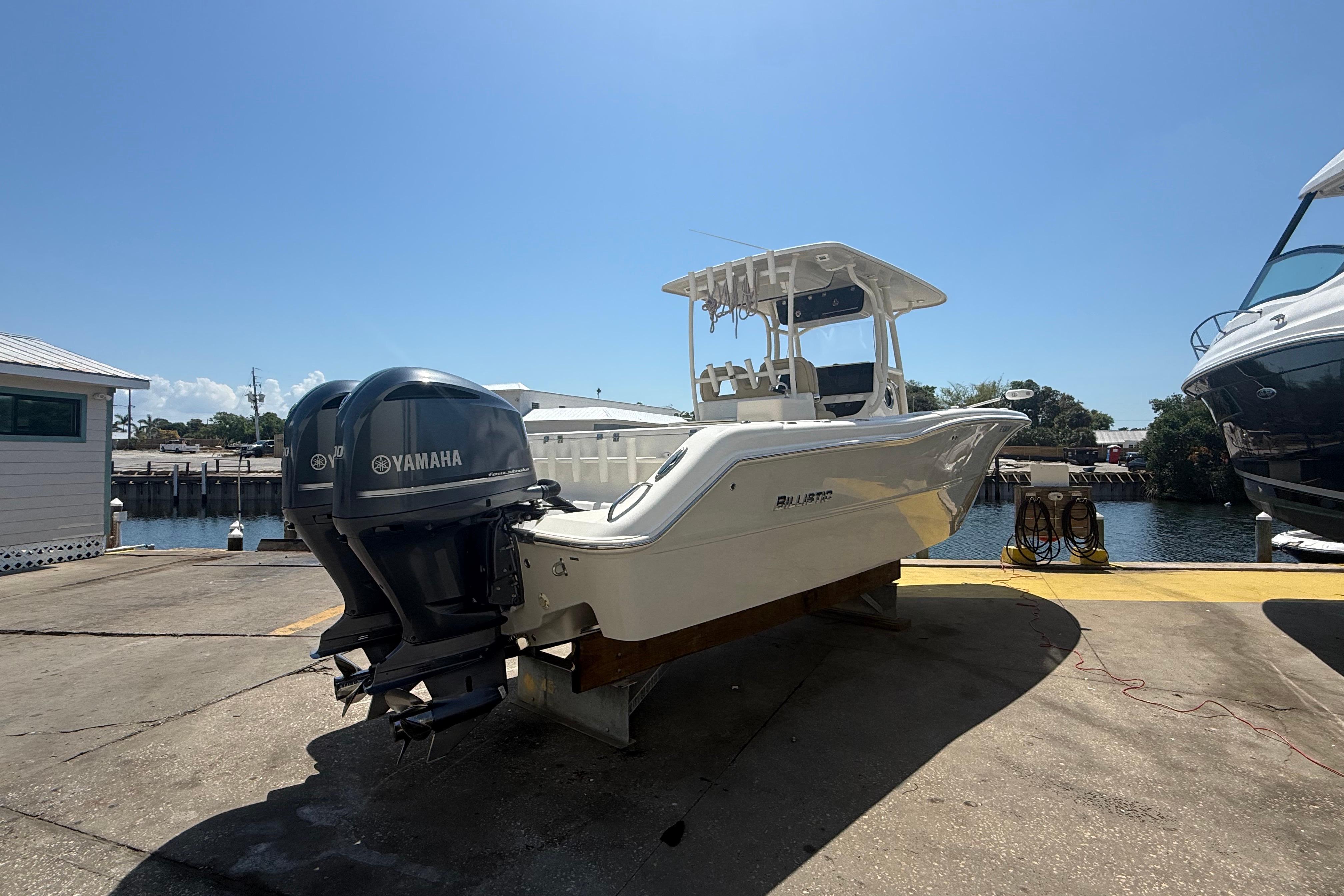 2019 Key West Billistic 281 Center Console boat with Yamaha engines docked by the water.