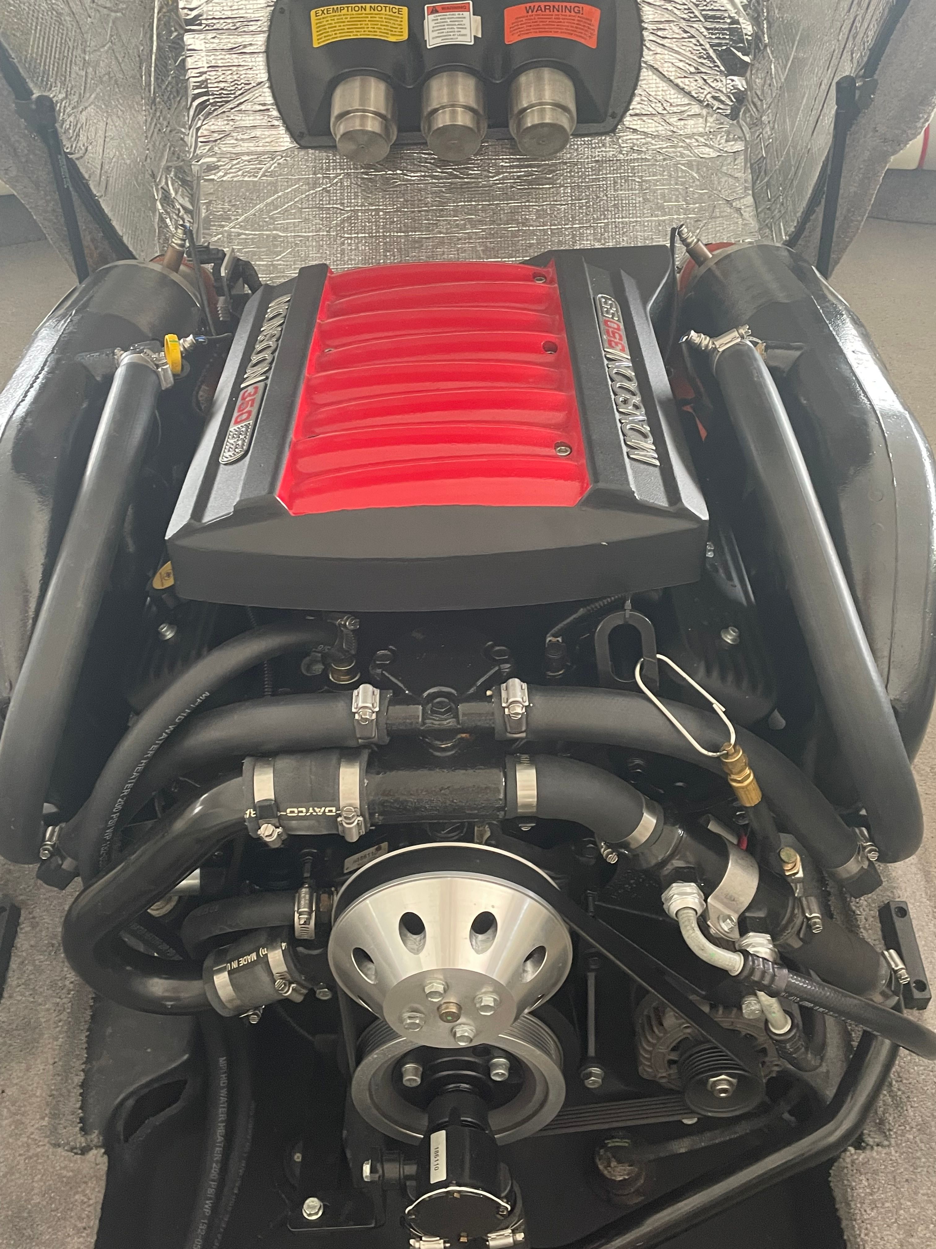 Engine of a 2014 Malibu Response TXi boat with red cover design.
