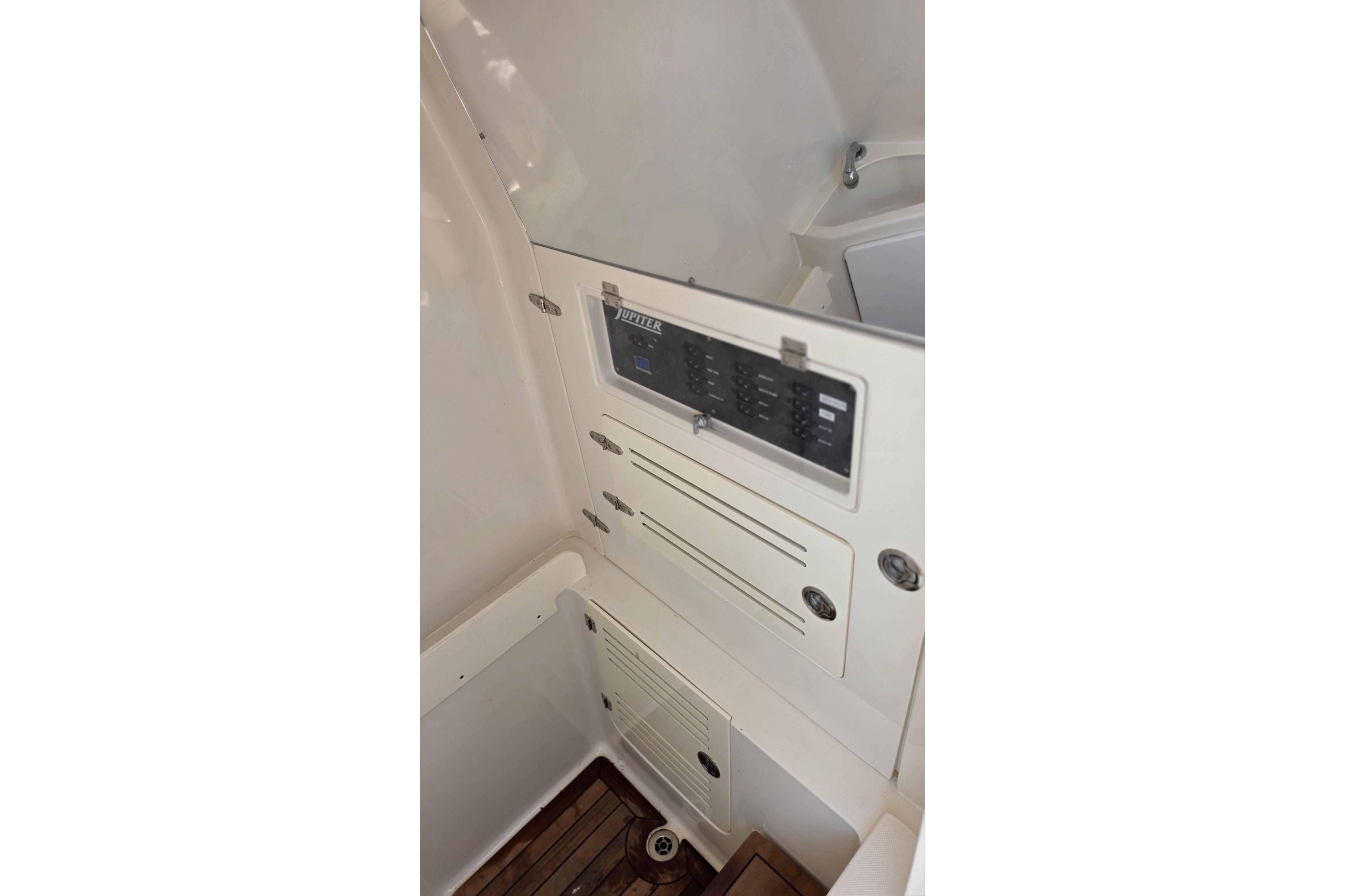 Control panel inside 2020 Jupiter 34 HFS boat, featuring switches and storage compartments.
