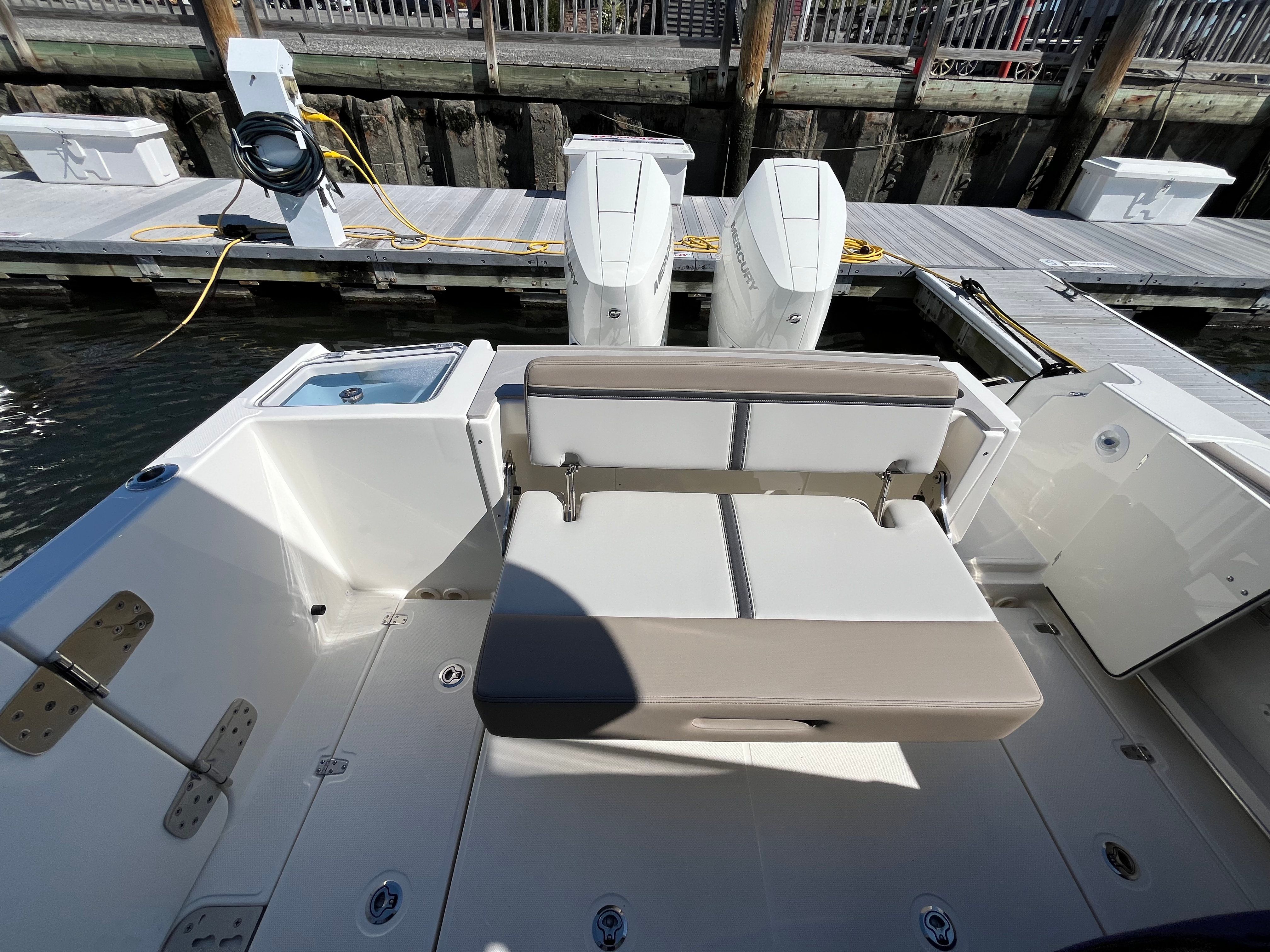 The image shows the stern of a Boston Whaler 330 Vantage with dual engines at the dock.