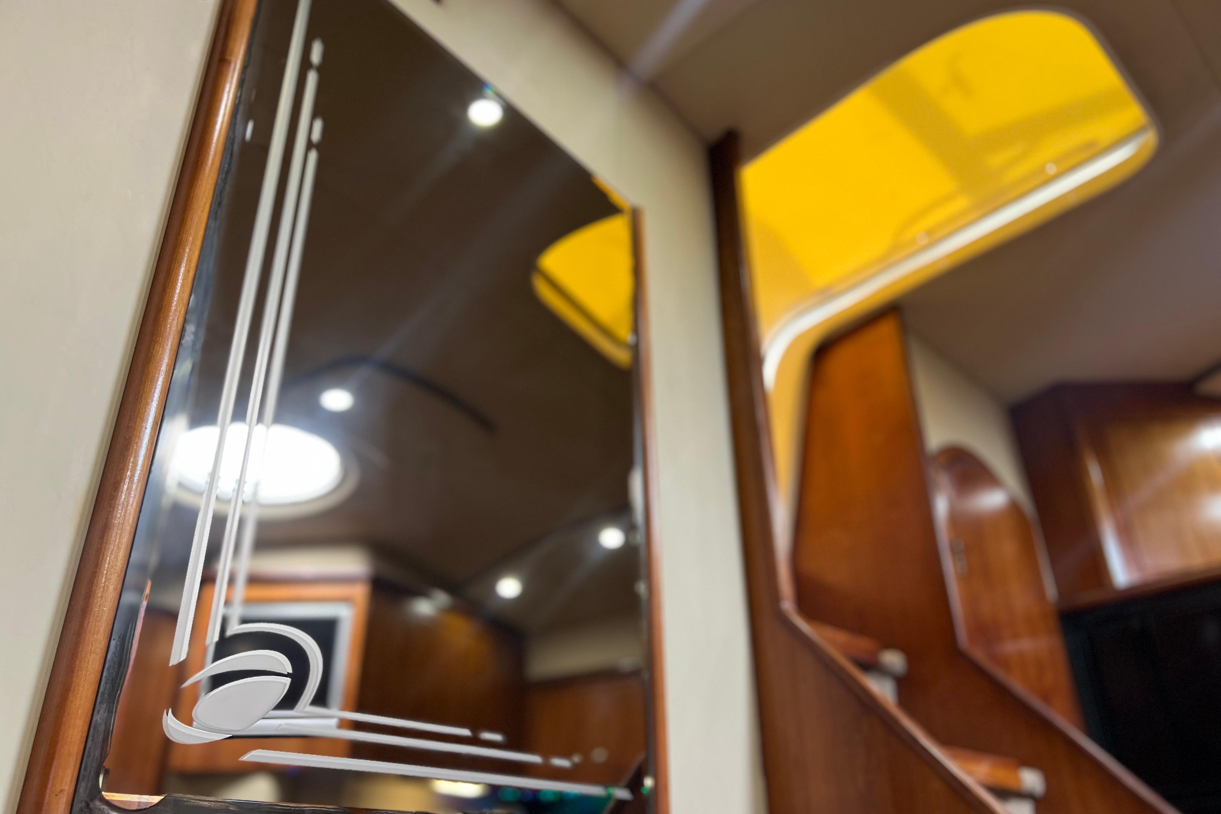 Interior of 2005 Cruisers Yachts 440 Express, featuring elegant wood finishes and modern lighting.