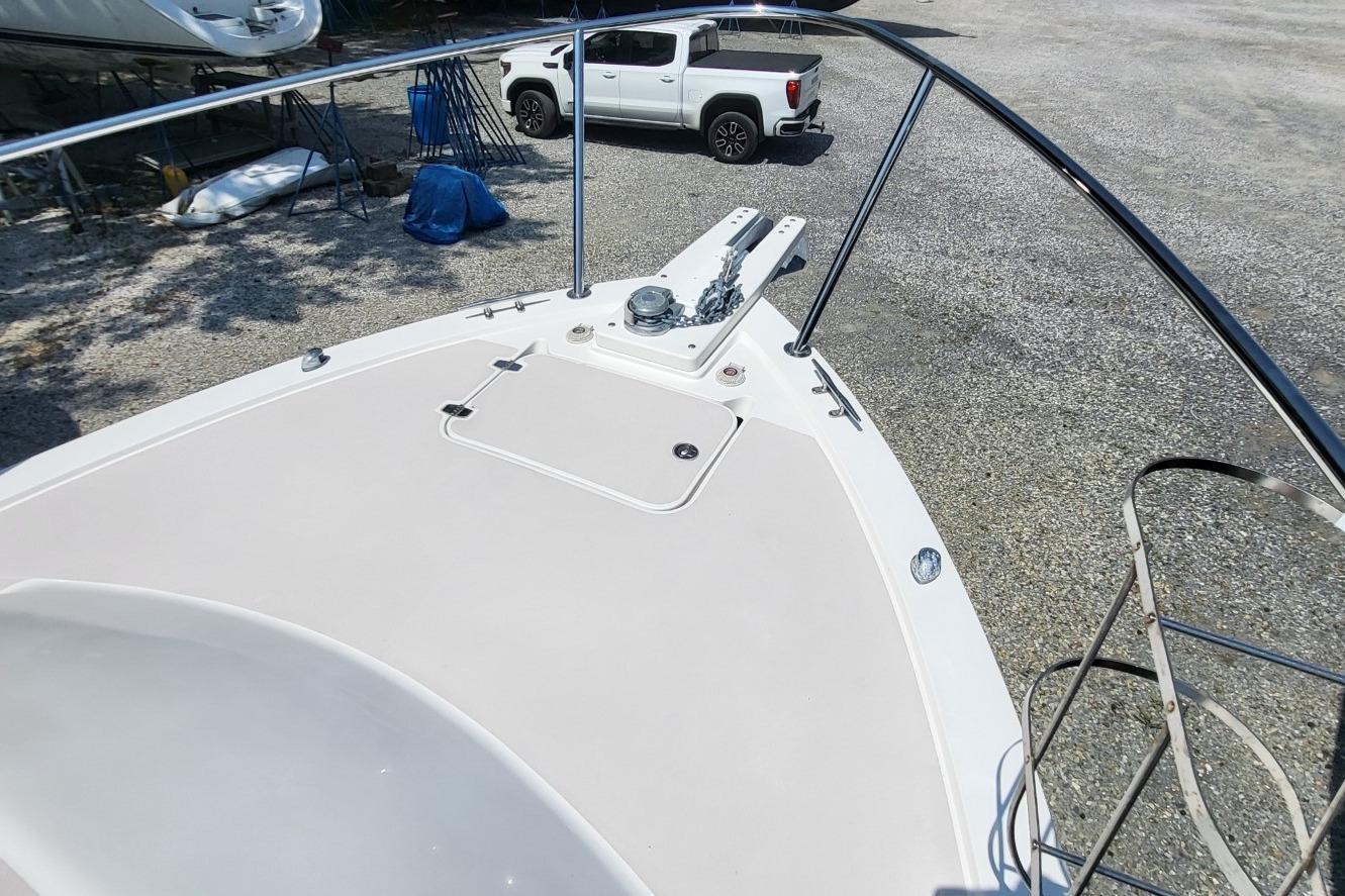 2006 Back Cove 29 boat deck with anchor, parked on gravel near a white truck.