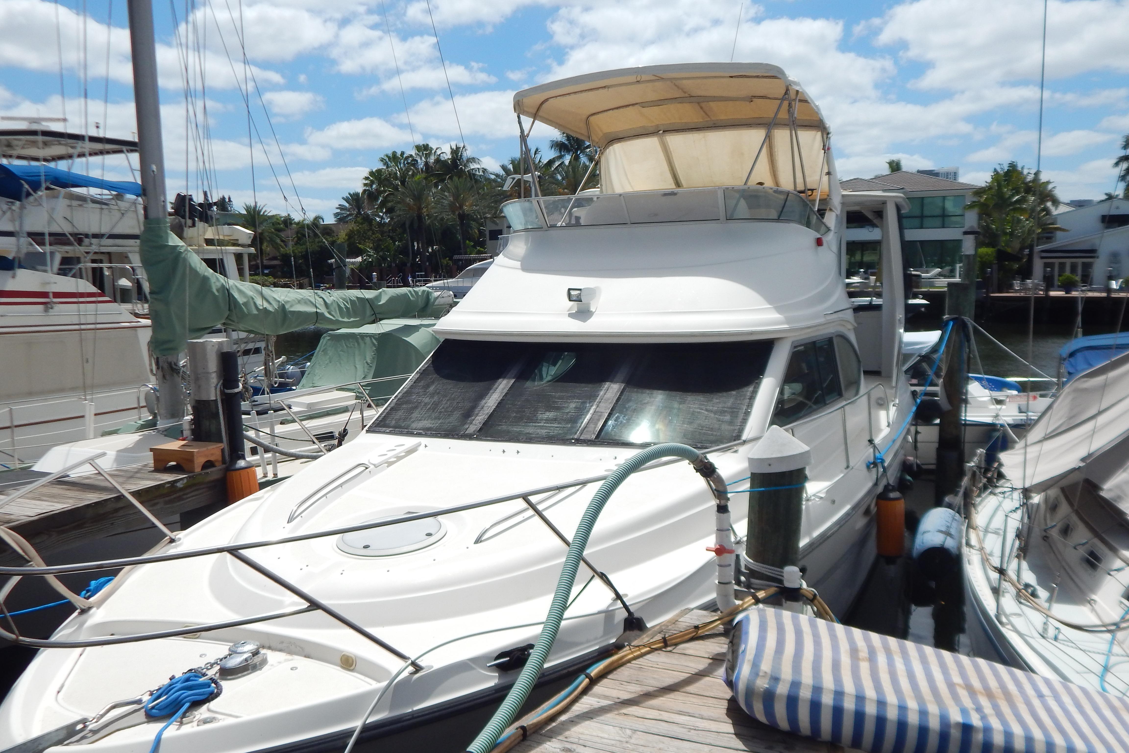 1998 Magnum 4100 SCR yacht docked at marina under sunny skies.