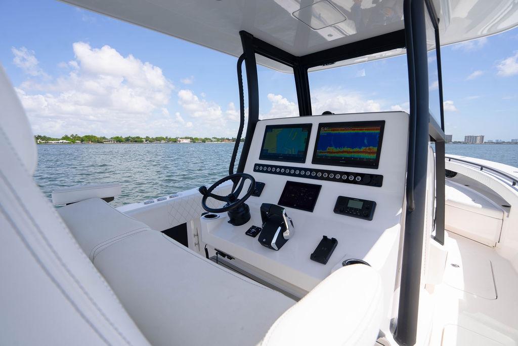 Modern helm of 2027 Reef Runner 340 boat with advanced navigation displays on open water.