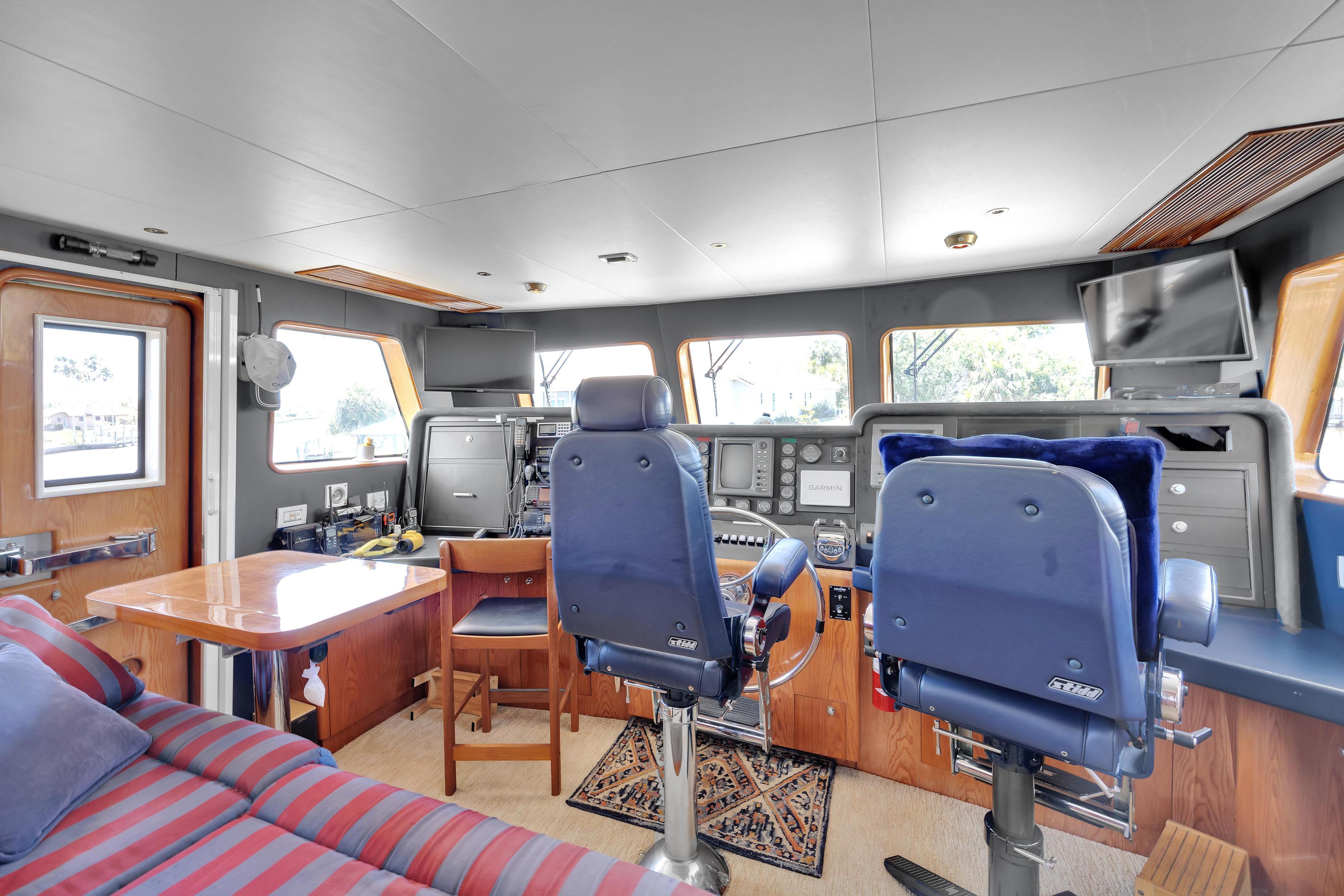 Interior of 2001 Cheoy Lee Expedition 70 yacht, featuring helm and seating area.