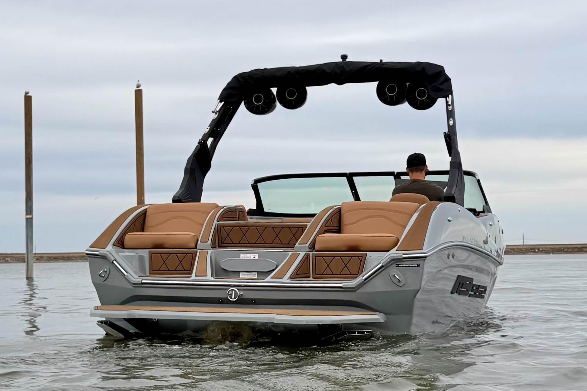 2026 MB B52 21 Alpha boat on water, rear view with sleek design and tan seating.