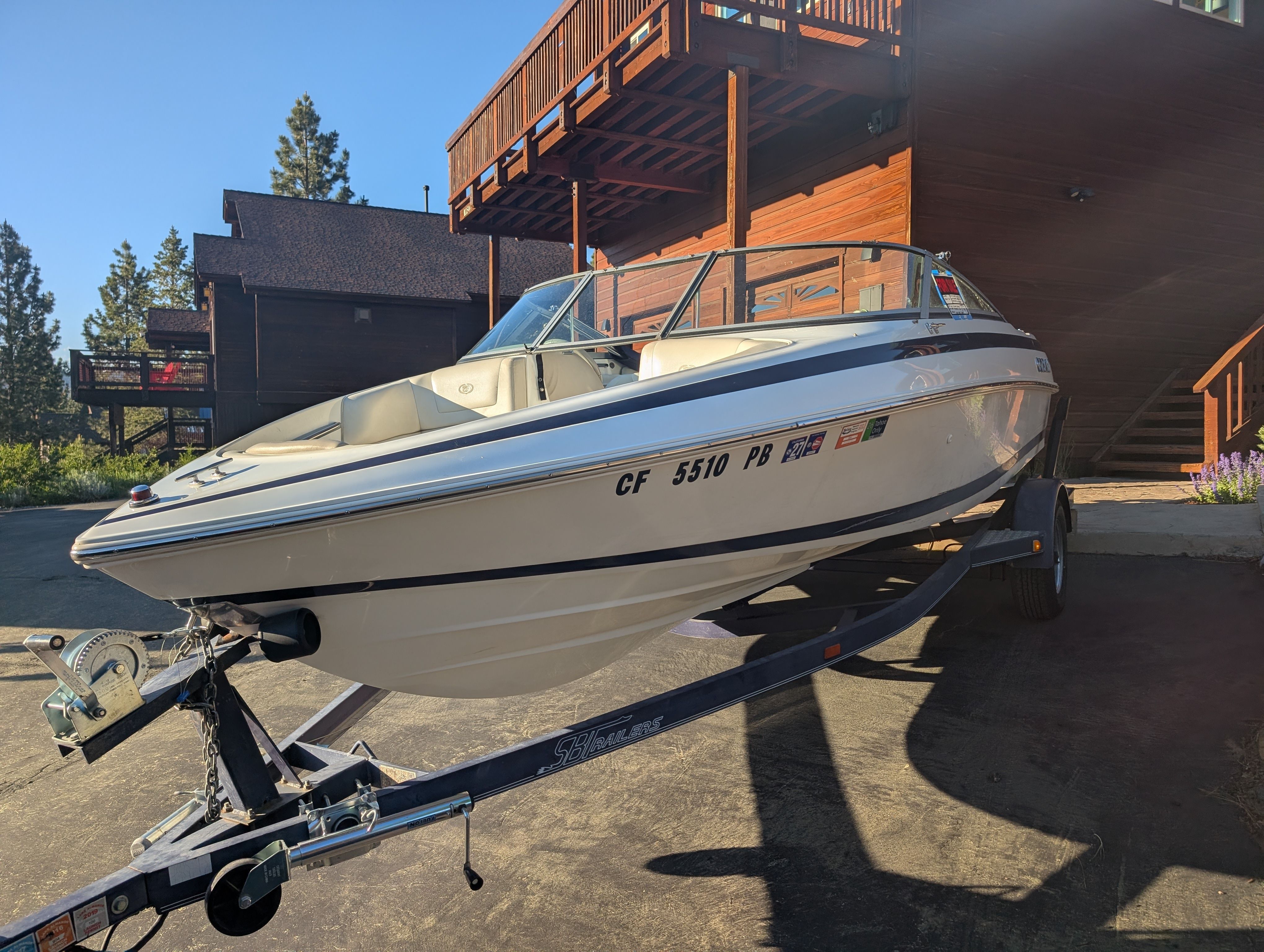 A 1997 Cobalt 190 boat on a trailer in front of a wooden building.