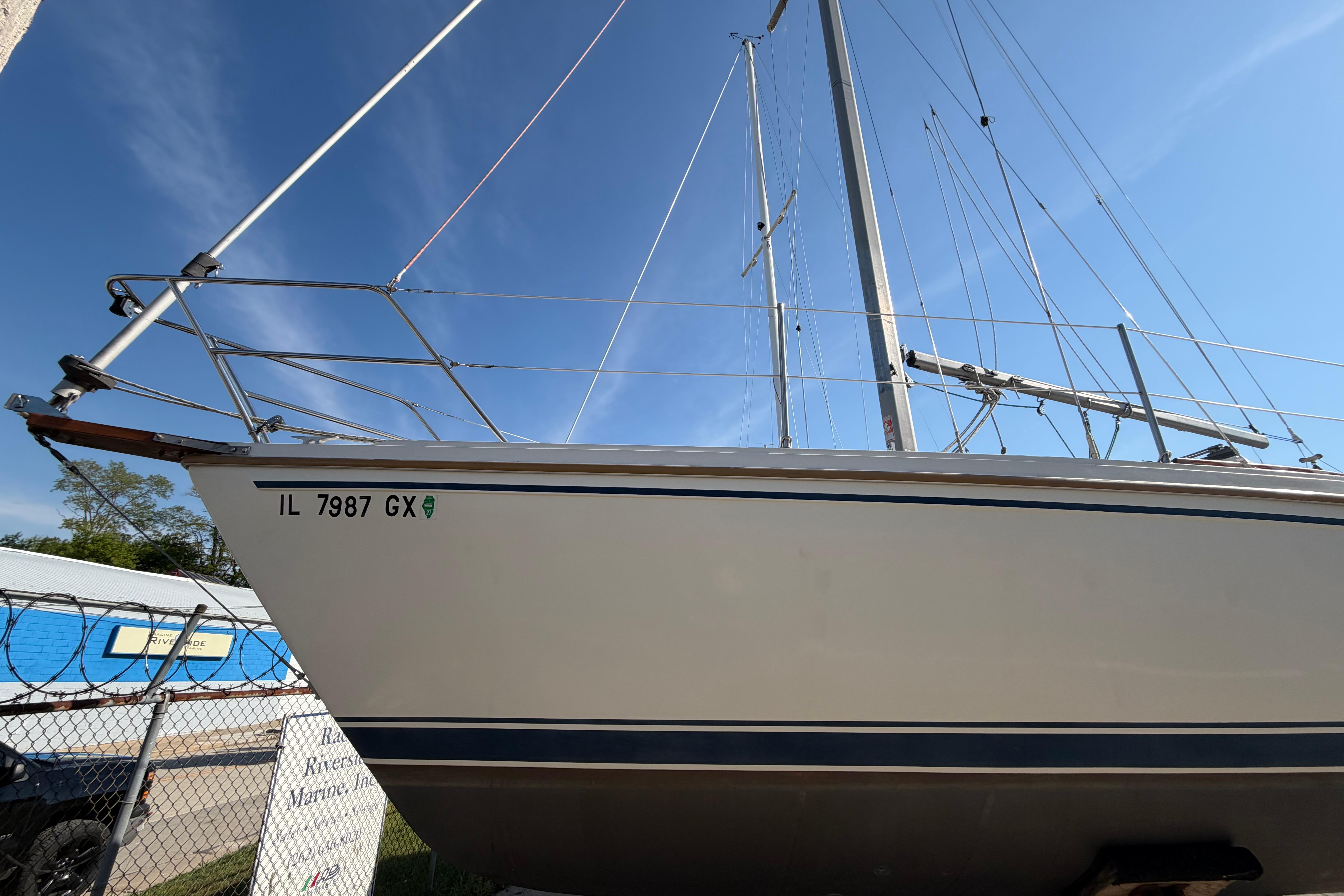 1988 Catalina 30 MkII sailboat with registration IL 7987 GX, docked under clear blue sky.