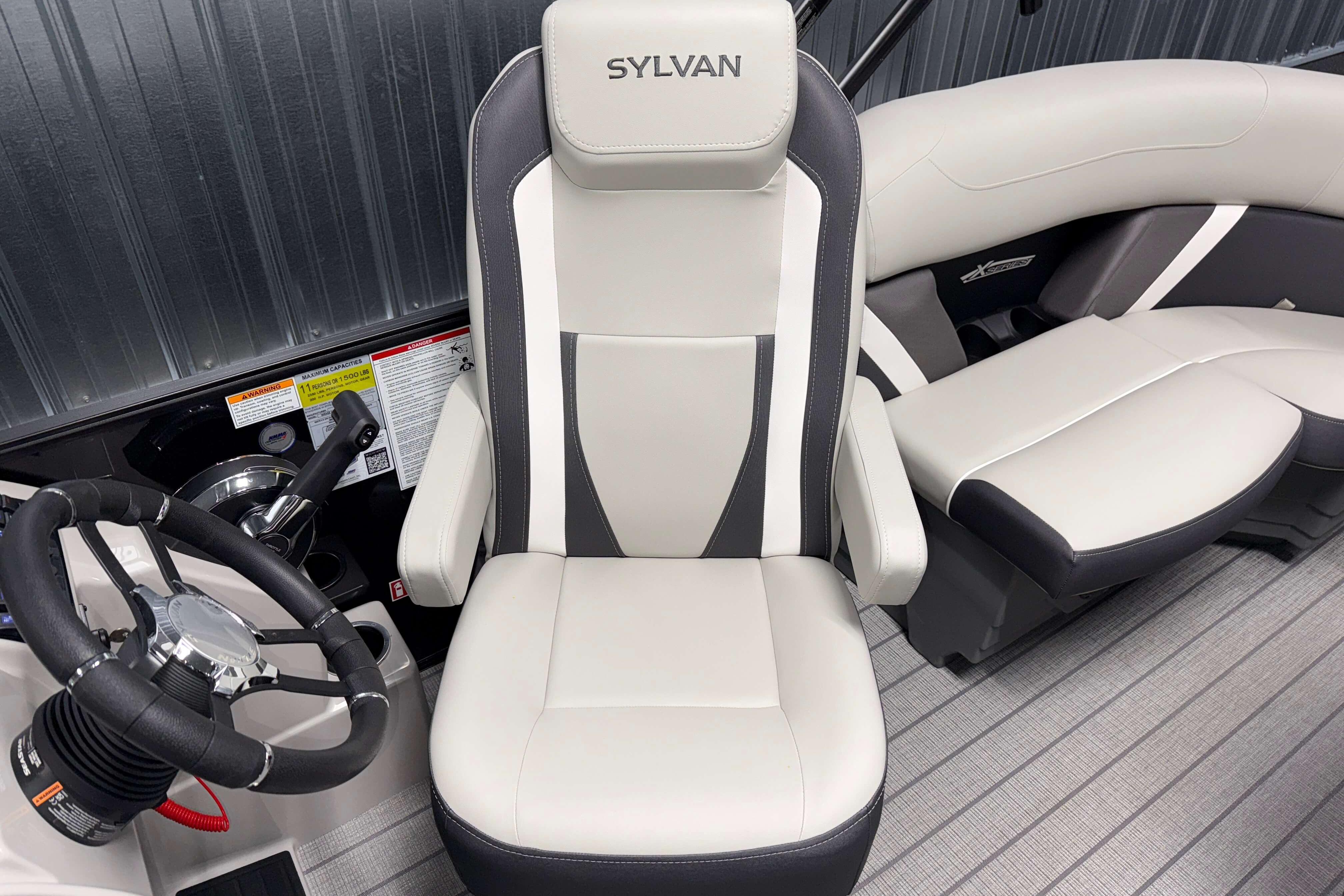 Captain's seat and steering wheel of 2026 Sylvan Mirage X1 boat interior.