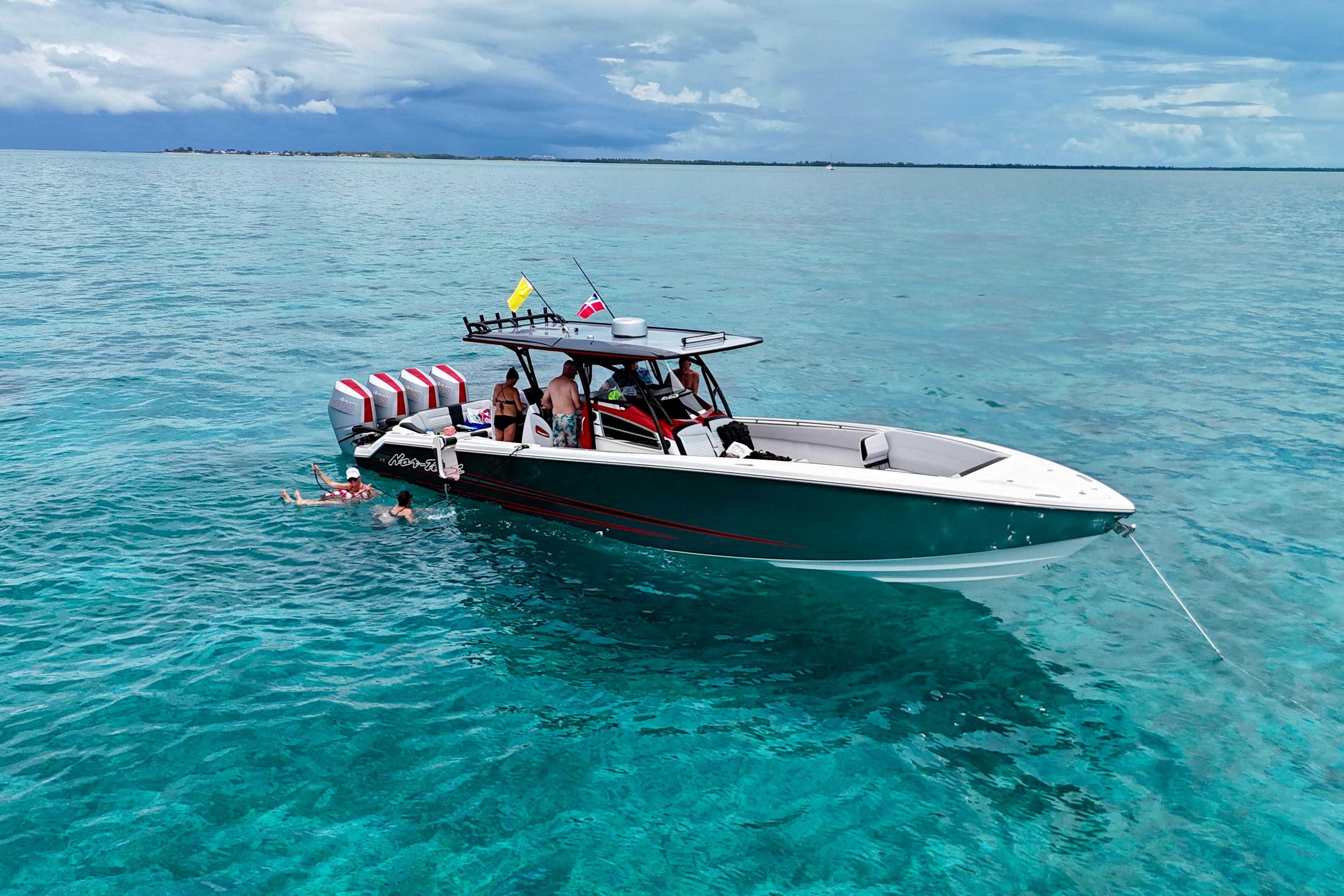 2026 Nor-Tech 390 Sport Center Console on clear blue water with swimmers nearby.