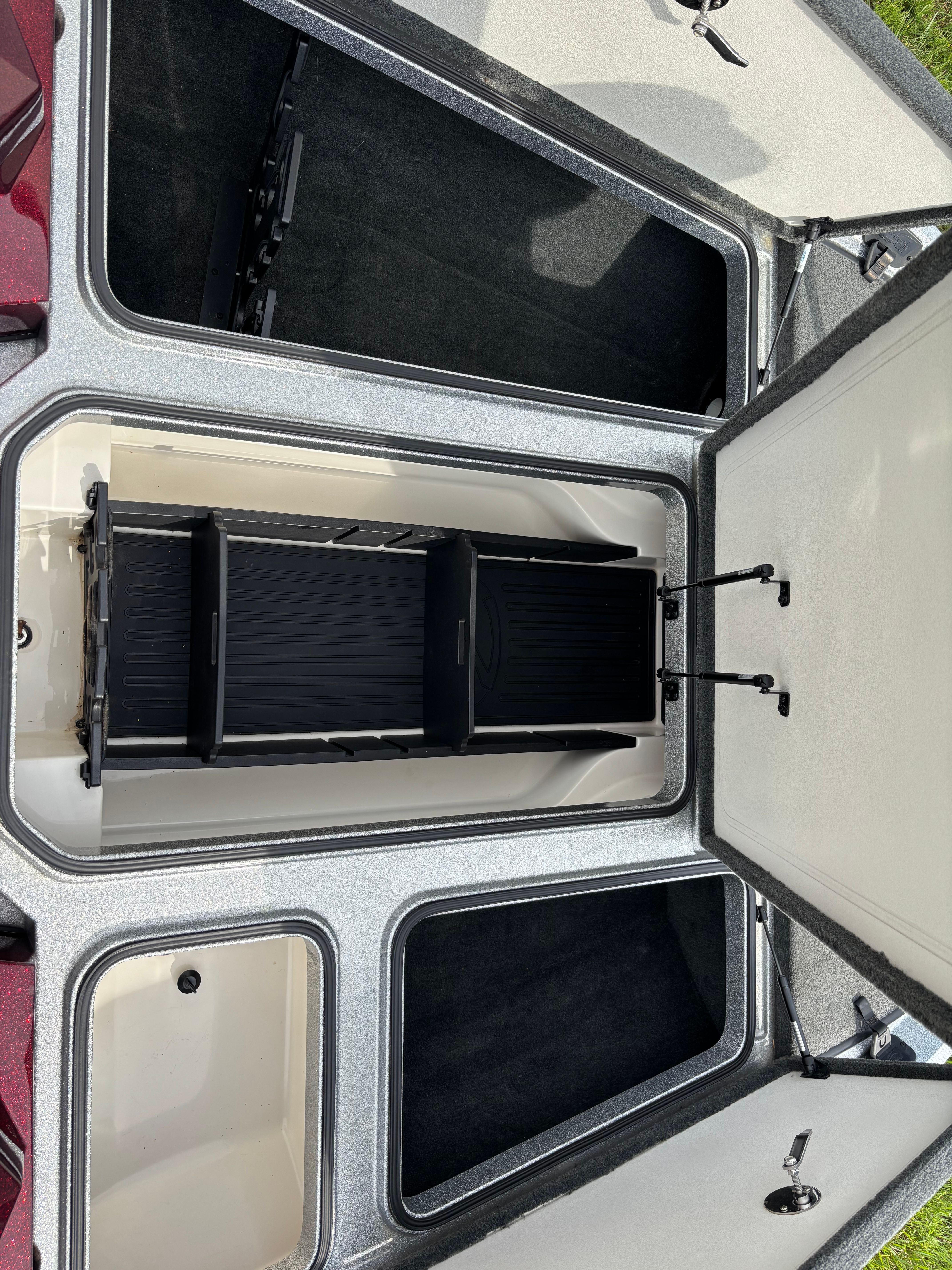 Open storage compartments on a Ranger Z 185 boat, showing interior sections and lids.