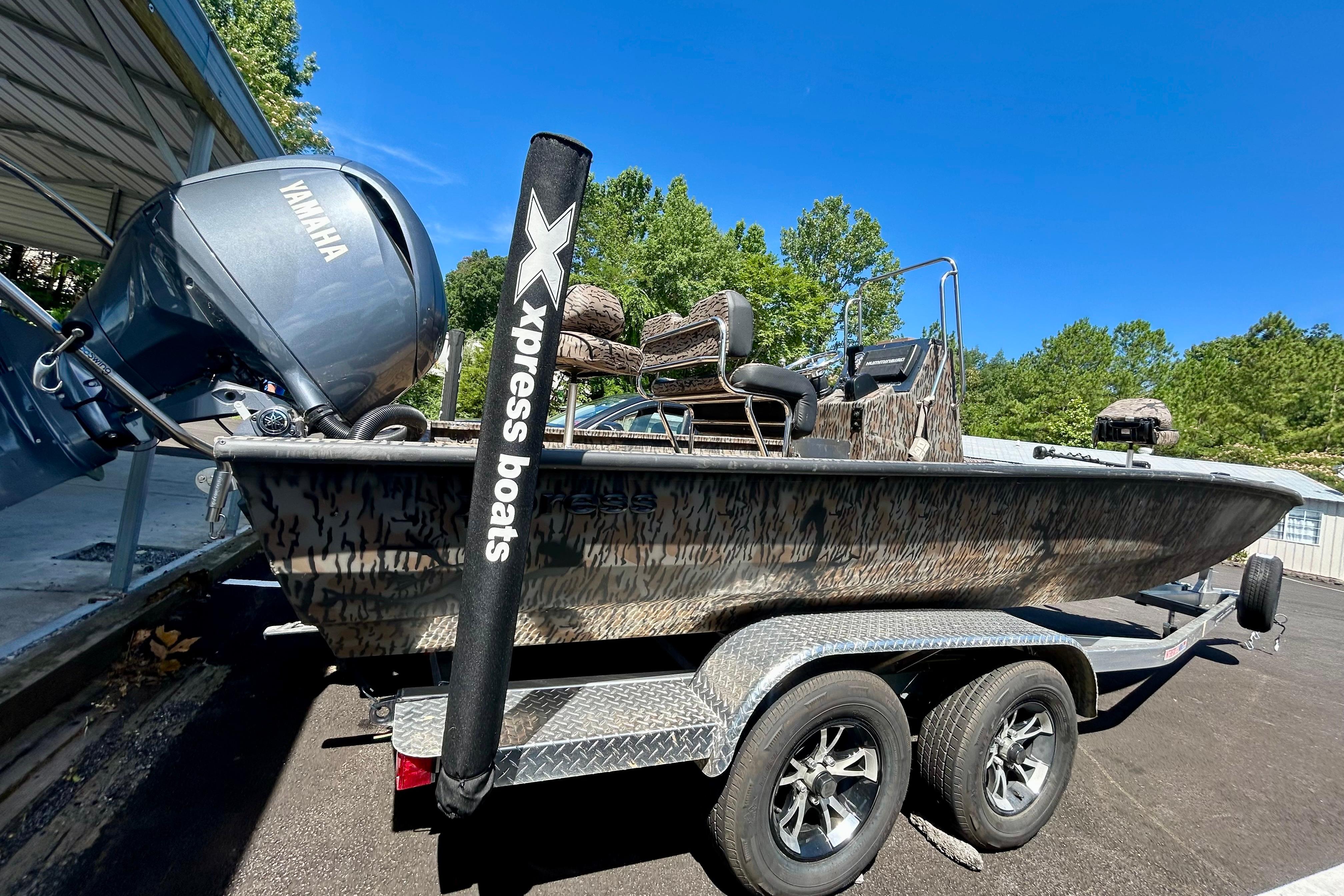2025 Xpress H22B Bay boat on trailer with Yamaha engine, parked outdoors.