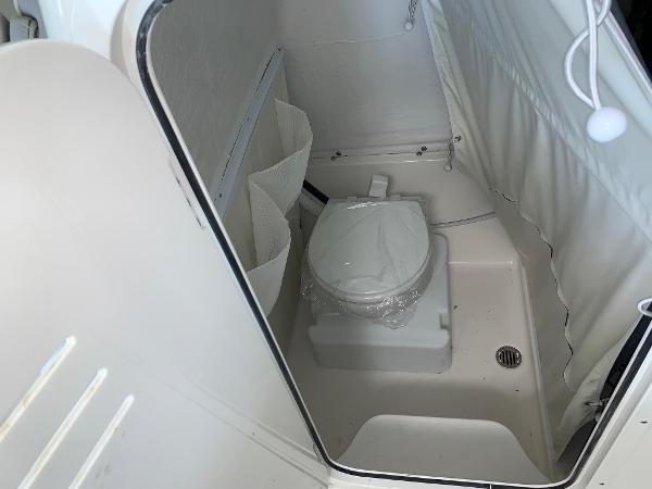 2024 Key West 263 FS boat interior bathroom with toilet and storage compartments.