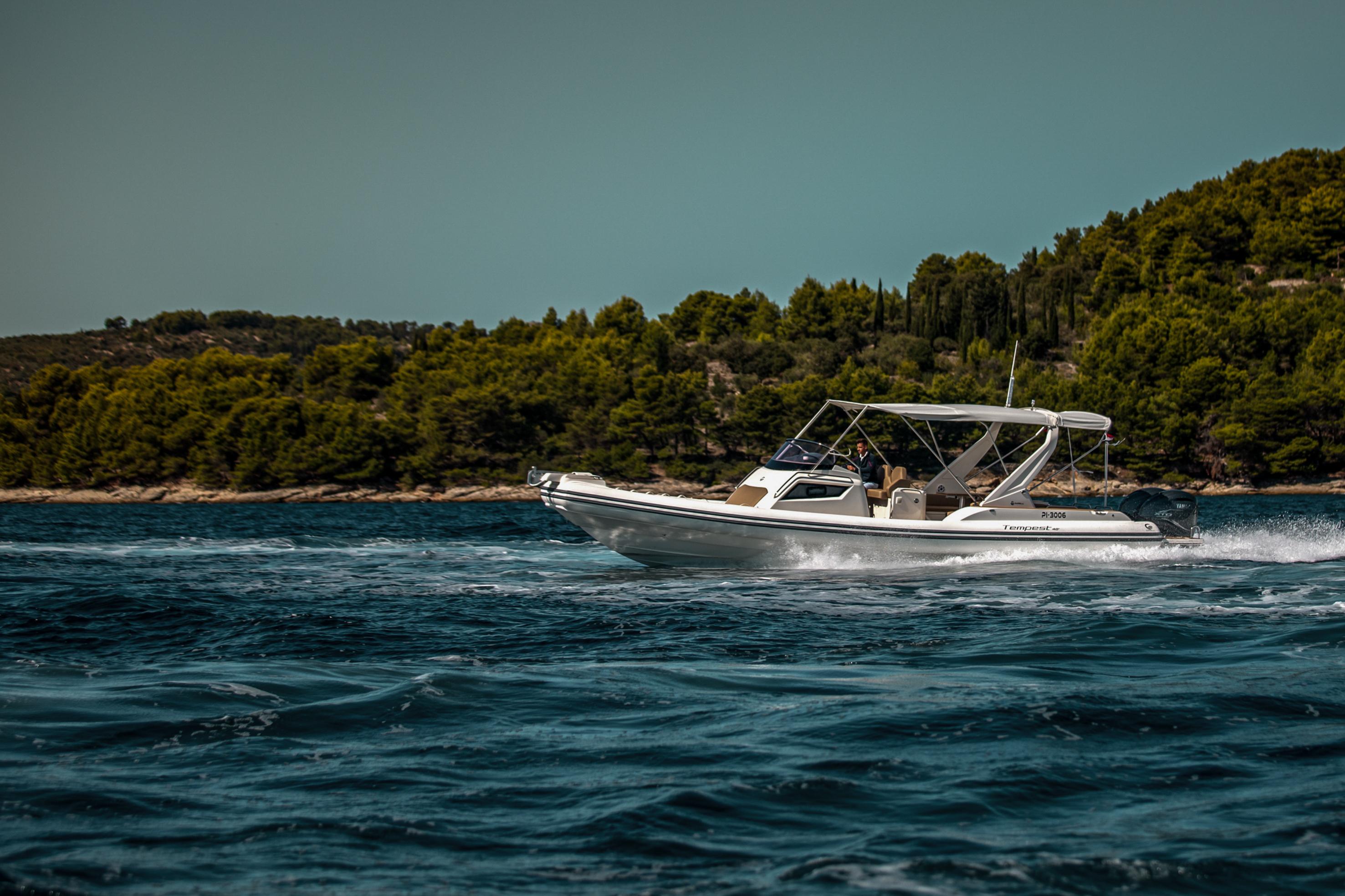 2022 Capelli Tempest 40 cruising on a scenic, forested coastline.
