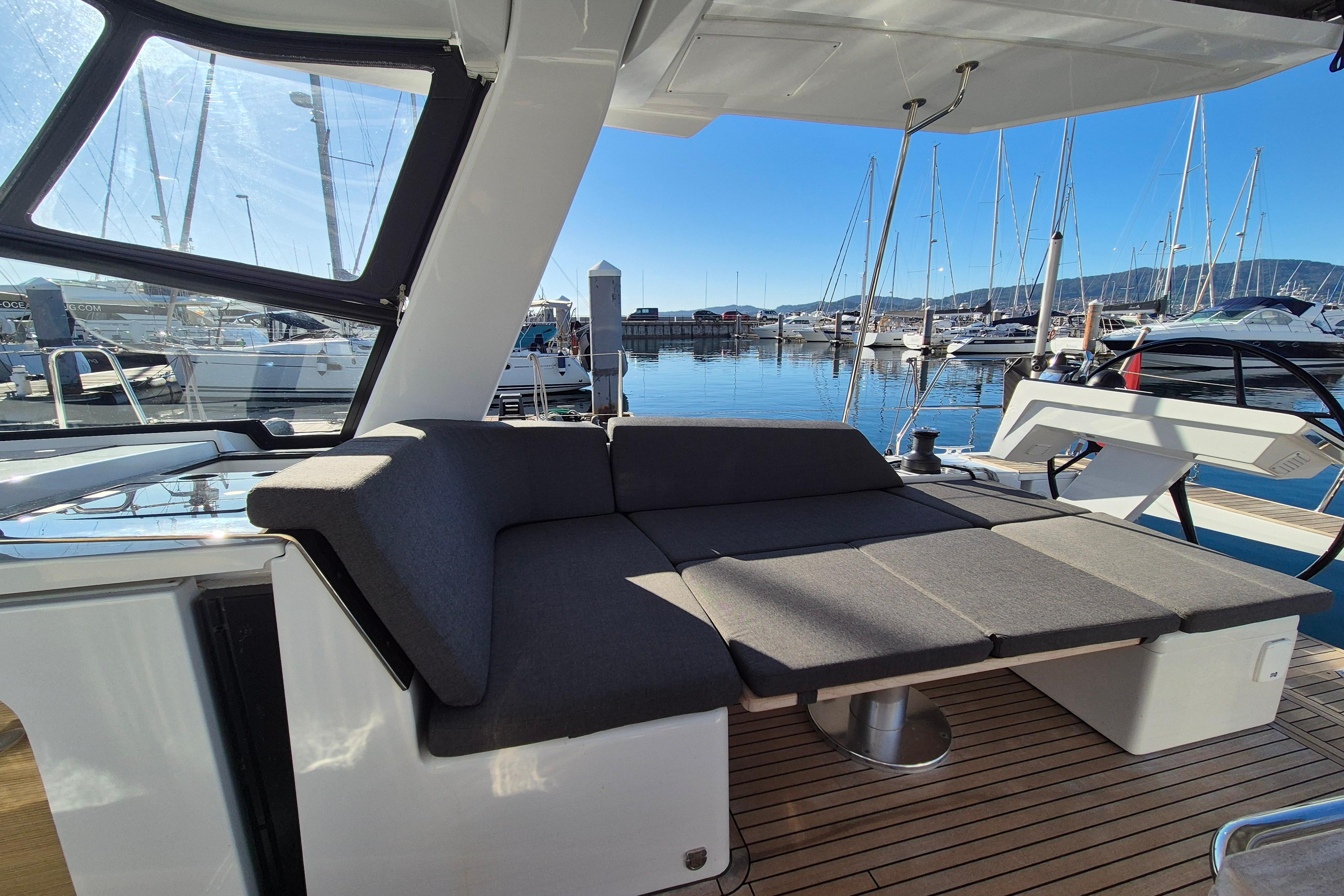 Luxurious 2024 Hanse 460 yacht interior with comfortable seating, docked at a marina.