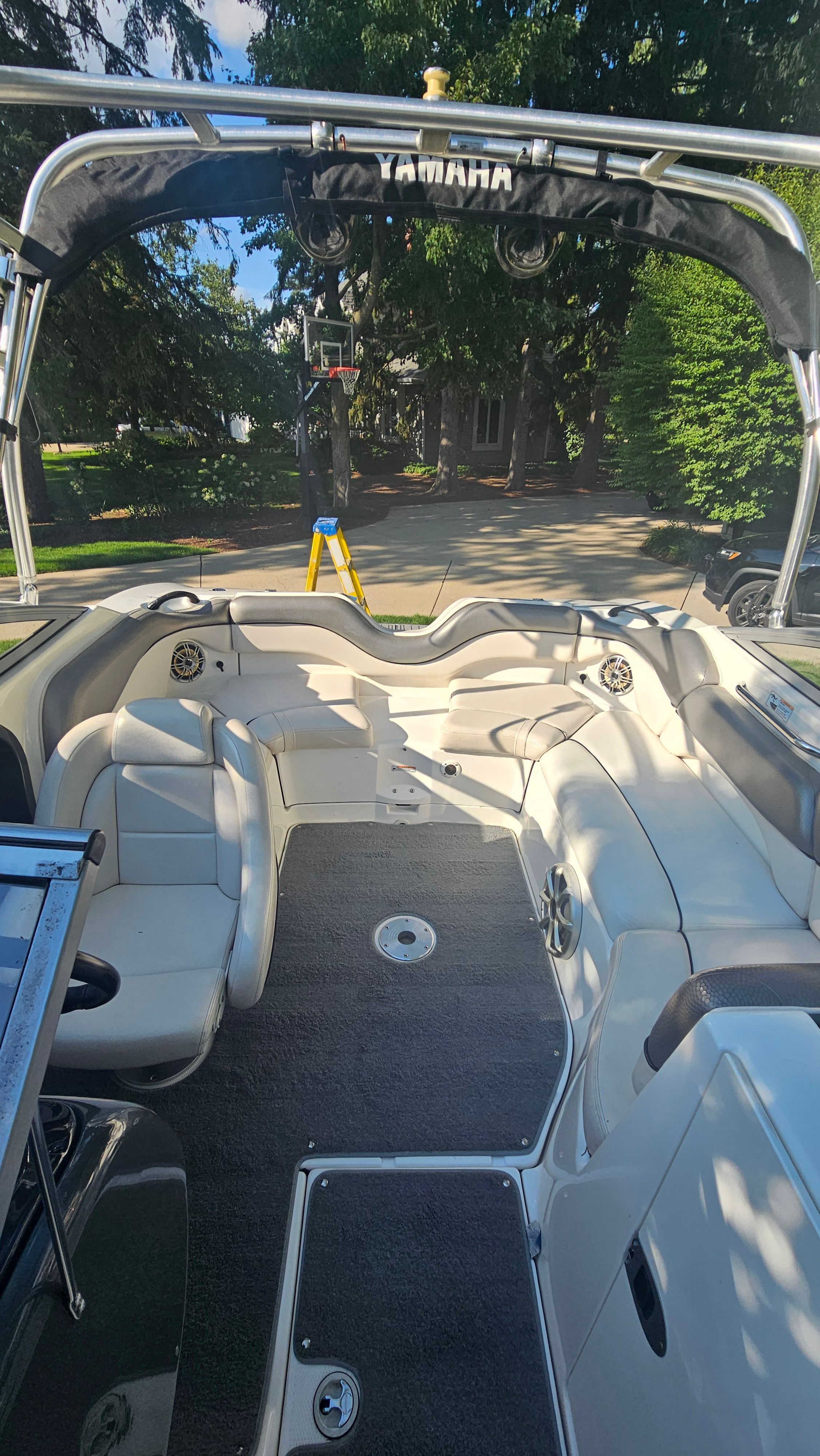 Interior view of a 2010 Yamaha AR210 boat with white seating and gray carpet.