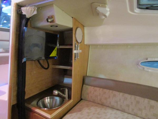 Interior of 2025 Cutwater C-248 Coupe featuring compact kitchenette and seating area.