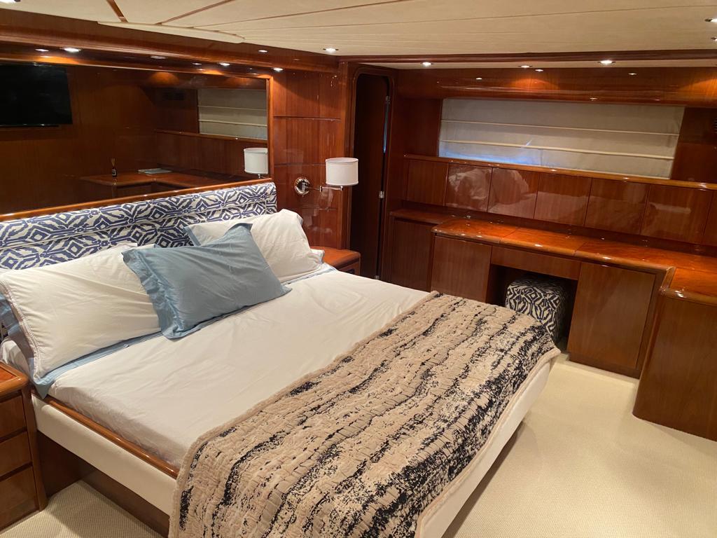 Luxurious bedroom interior on 2008 Falcon 86 yacht with elegant wood finishes.