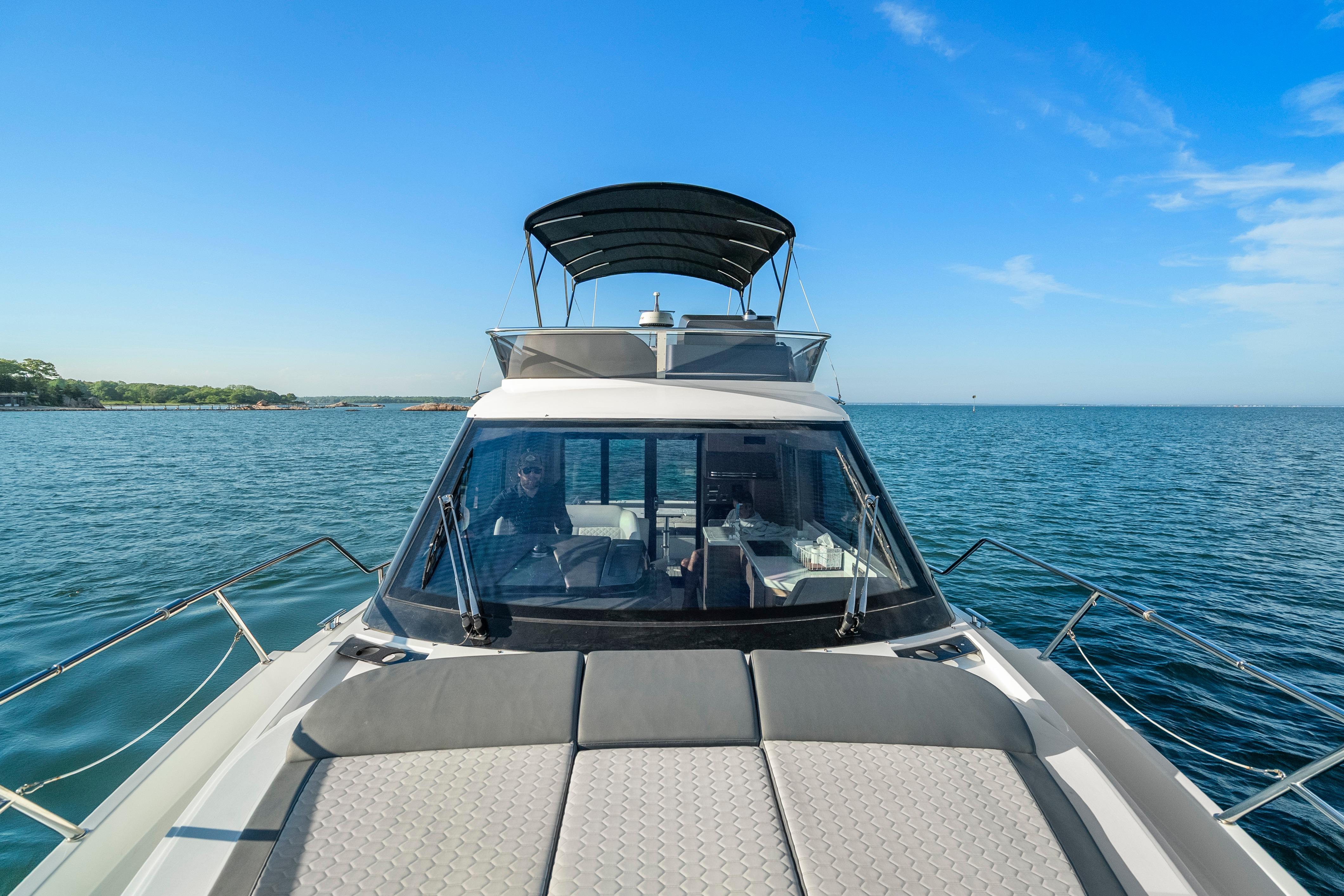 2023 Galeon 400 Fly yacht cruising on open water under clear blue skies.