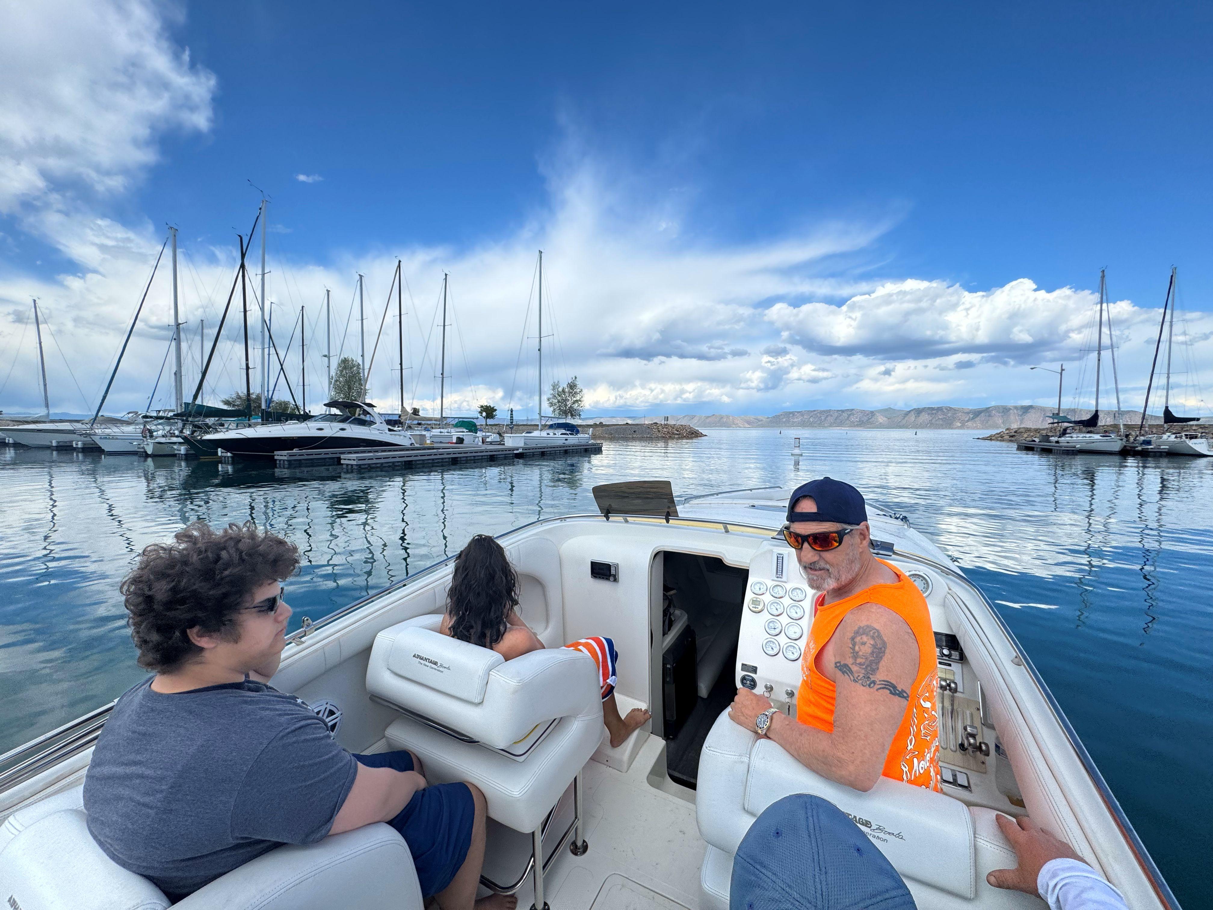 People enjoying a boat ride on a 2002 Advantage Victory, with marina in the background.