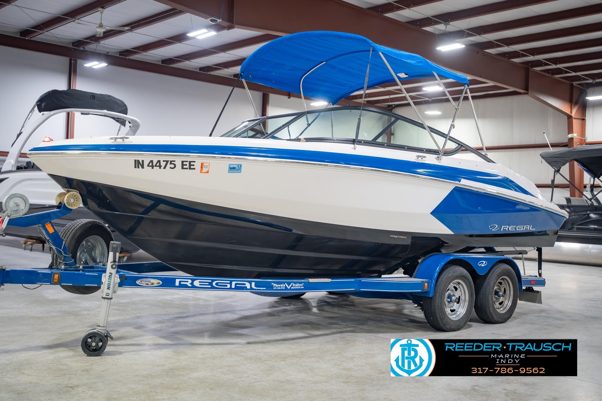 2015 Regal 2000 ESX Bowrider boat with blue canopy on trailer in showroom.