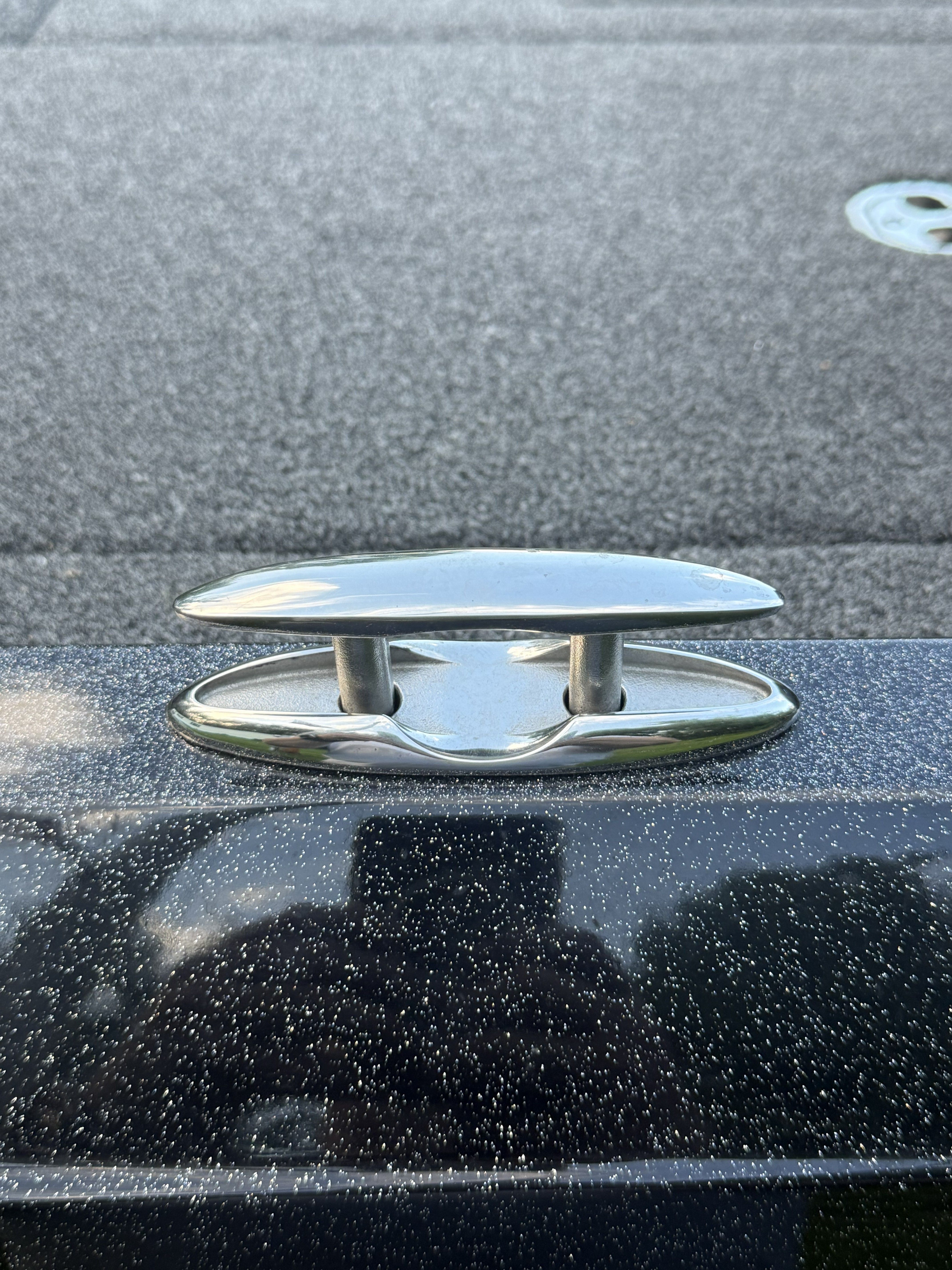Close-up of a shiny metal cleat on a boat.
