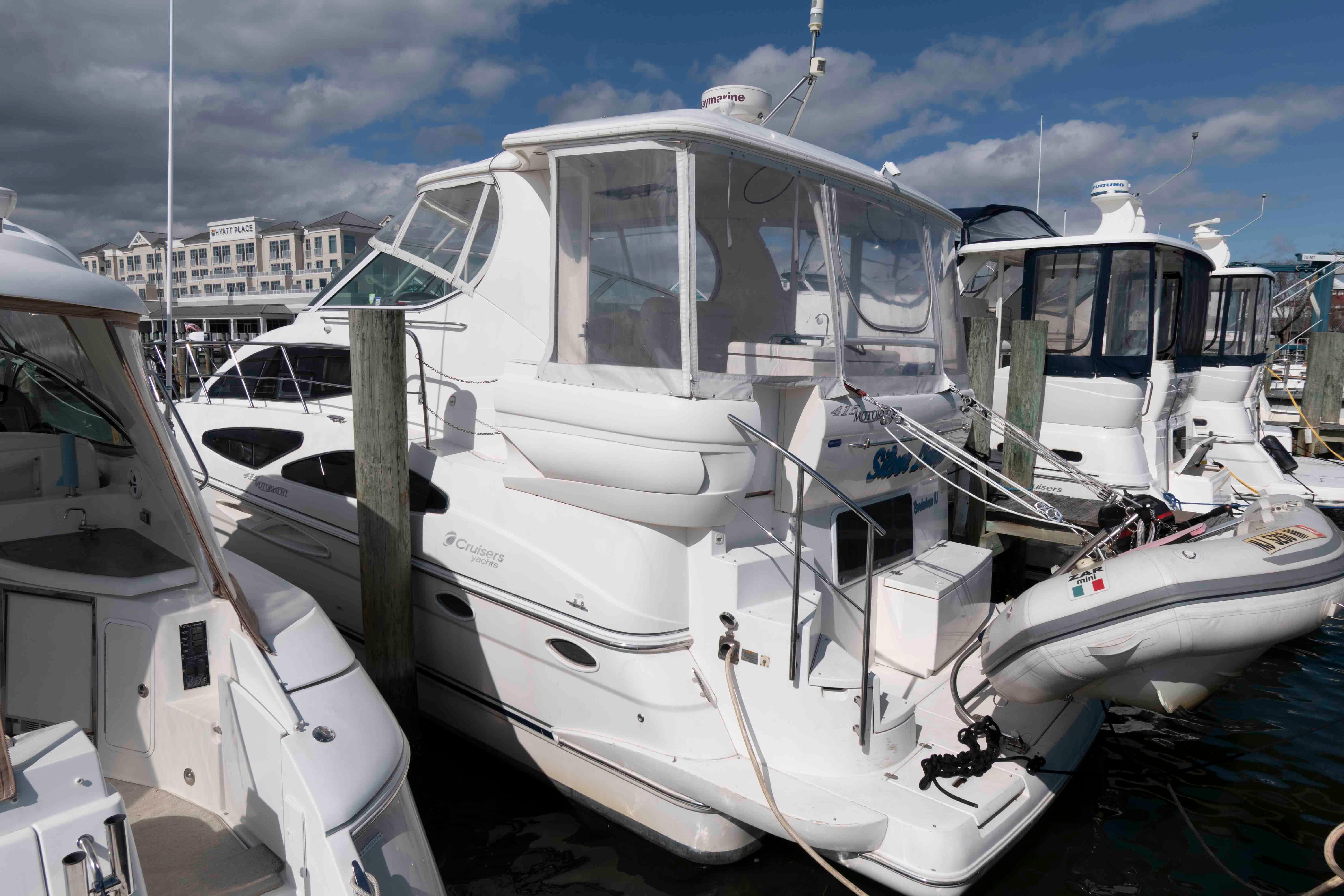 2007 Cruisers Yachts 415 Express Motoryacht docked at marina under cloudy sky.