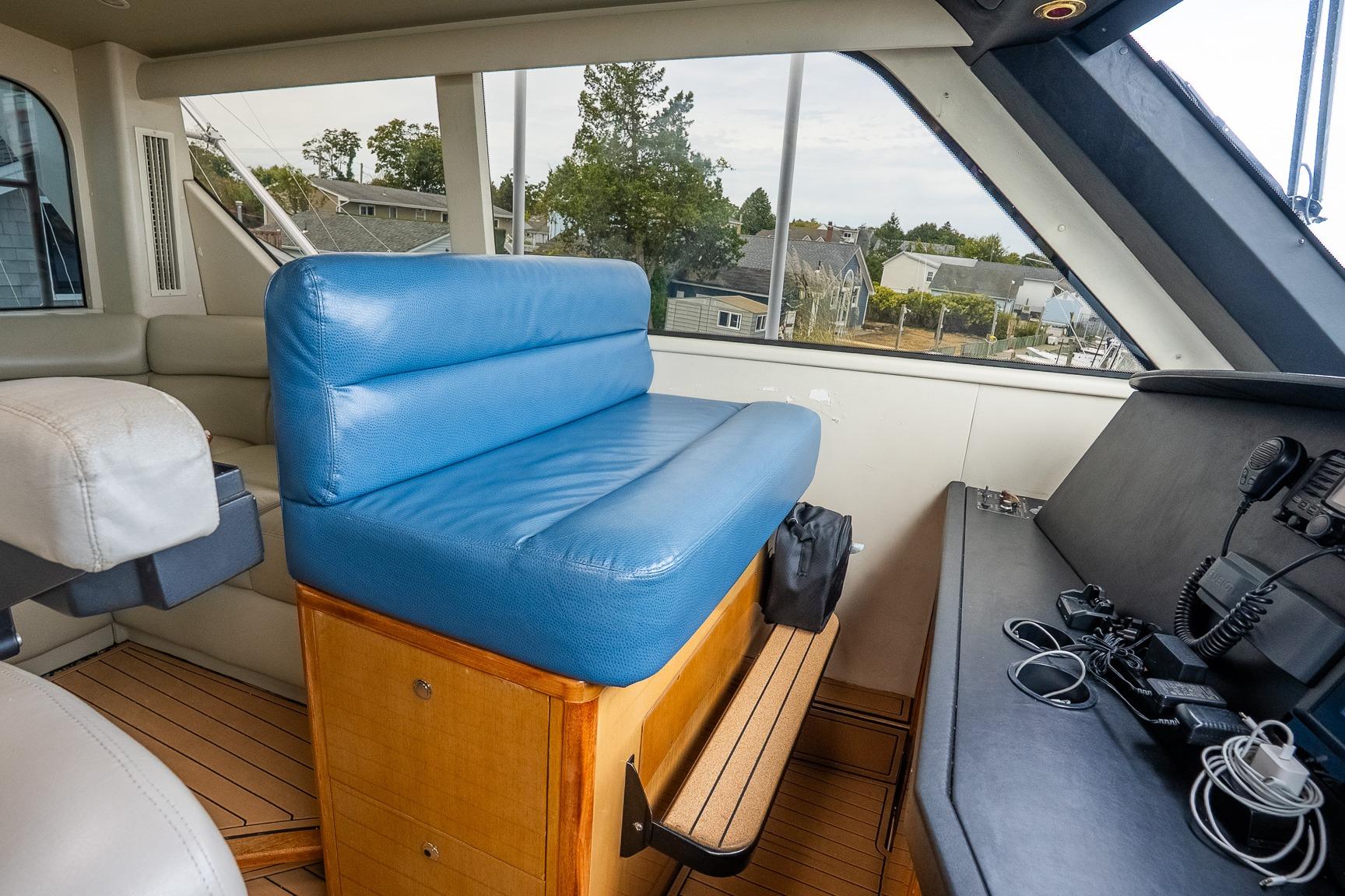 Interior of 2002 Viking 61 Enclosed Bridge yacht with blue seating and navigation equipment.