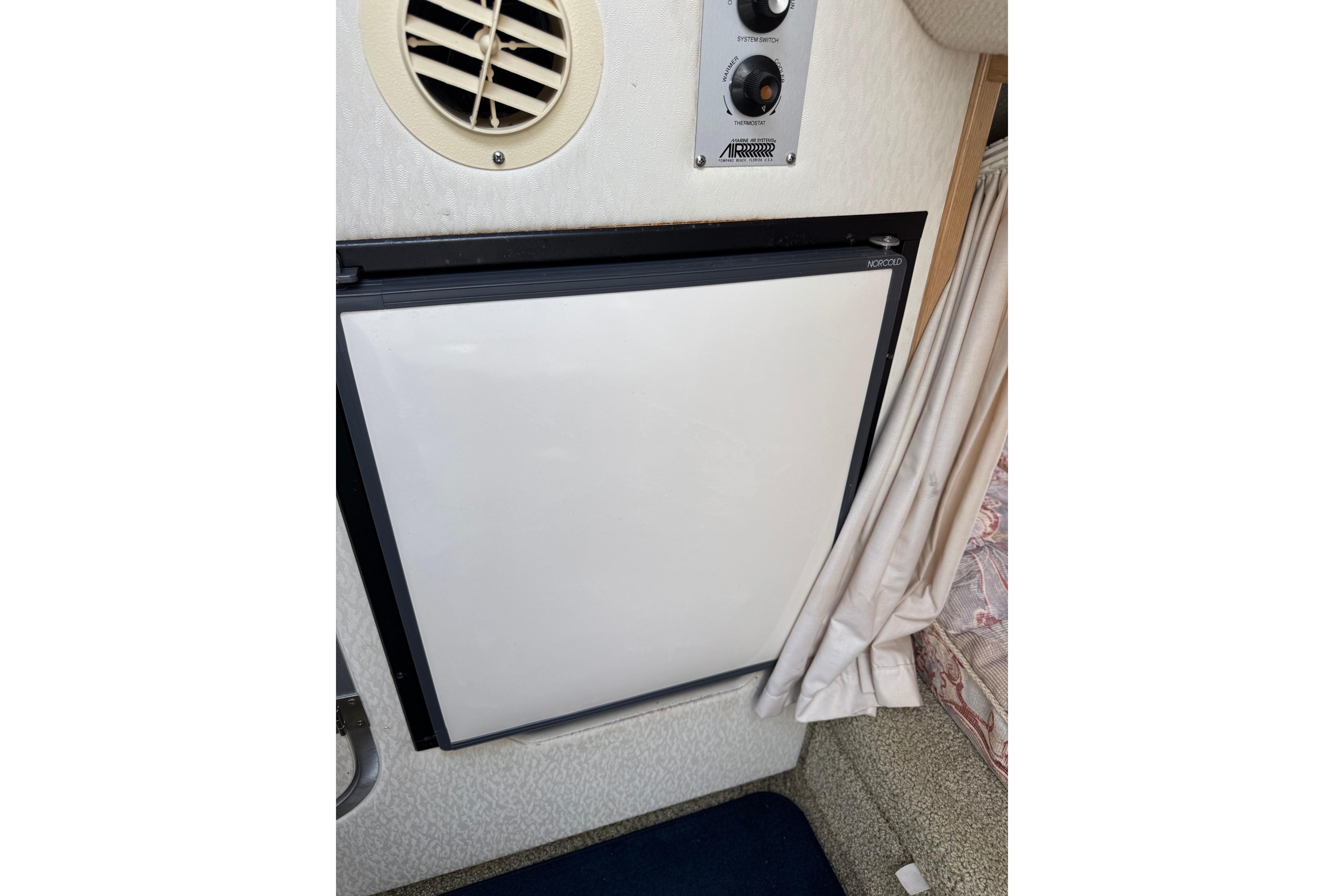Interior view of a 2000 Maxum 2400 SCR boat featuring a Norcold refrigerator.